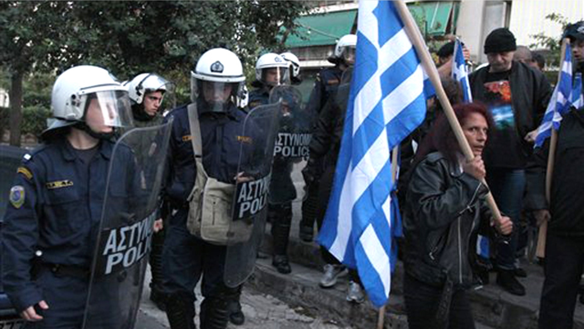 In this image taken Tuesday, Nov. 16, 2010 riot police look on a residents protest against Muslim immigrants holding outdoor prayers nearby.
