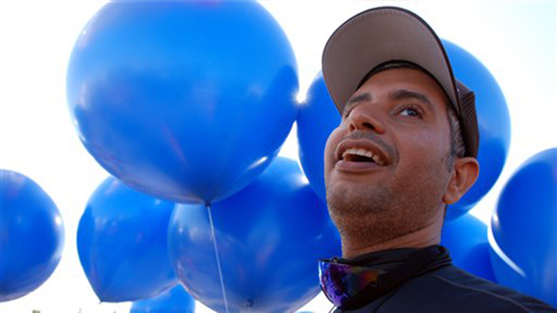 July 14, 2012: Iraqi adventurer Fareed Lafta watches with delight as party balloons are flated with helium to carry him aloft in a tandem lawn chair rig with gas station owner Kent Couch in Bend, Ore..