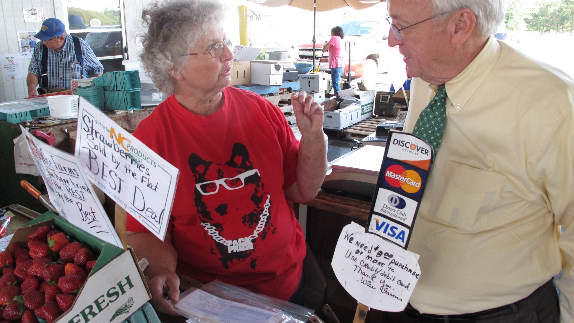 May 8, 2012: Kevin Concannon, U.S. undersecretary of agriculture, chats with vendor Helen Wise at the State Farmers Market in Raleigh, N.C.