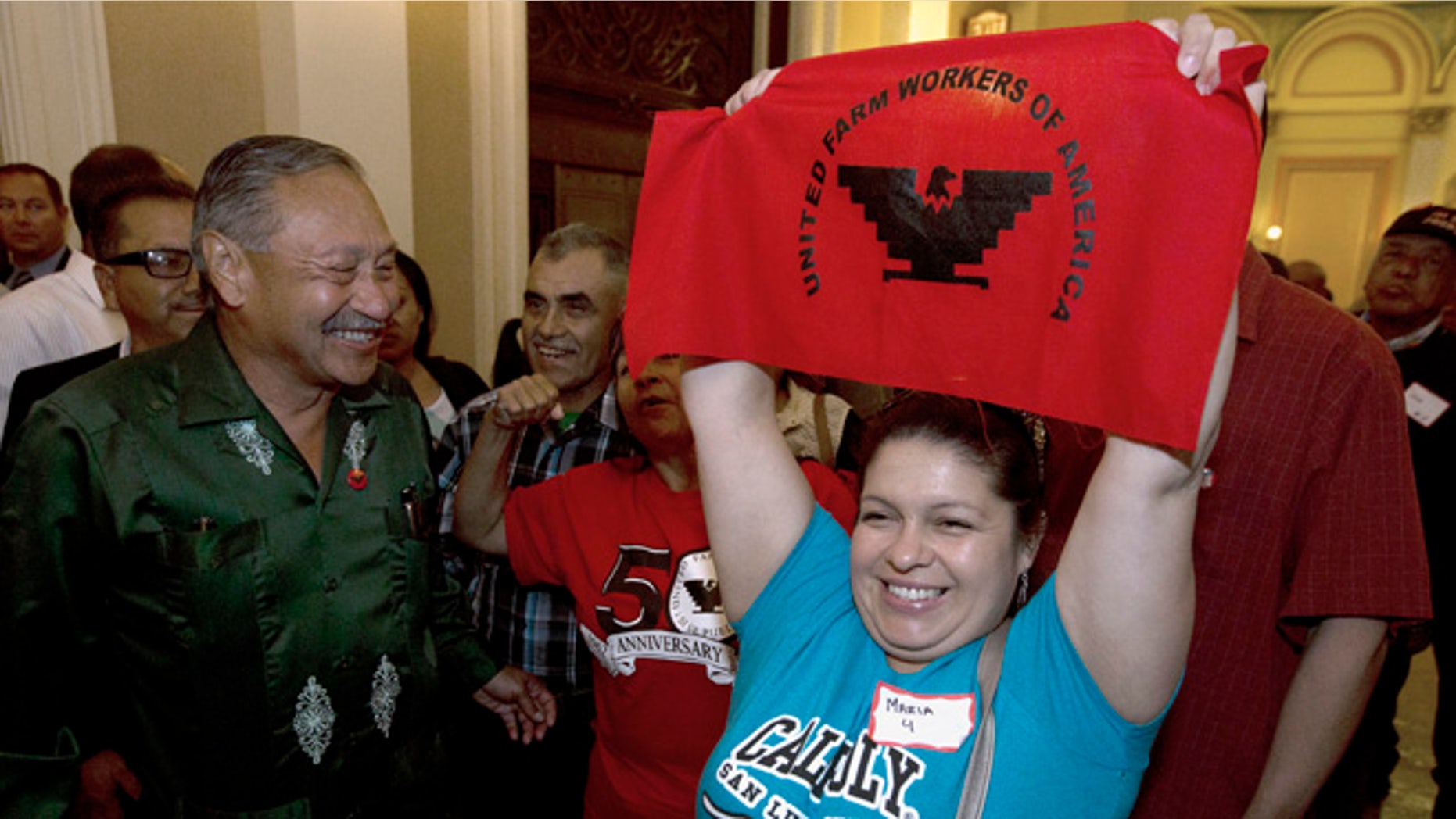 Maria Ceja and other farm workers celebrate outside the Assembly Chambers in Sacramento, Calif. Calif.