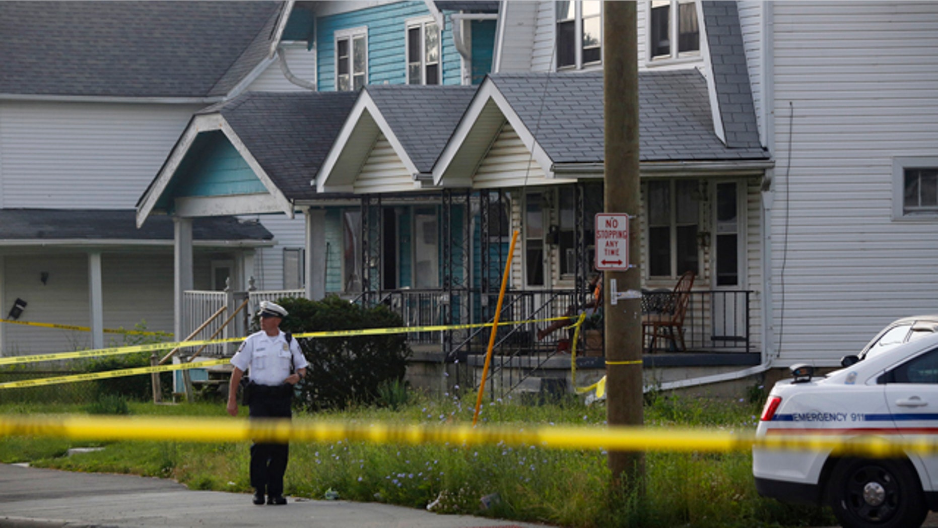 June 13, 2015: A police officer stands at the scene after multiple people were killed and a teenage girl injured in a shooting inside a home in Columbus, Ohio. (Tom Dodge/The Columbus Dispatch via AP)