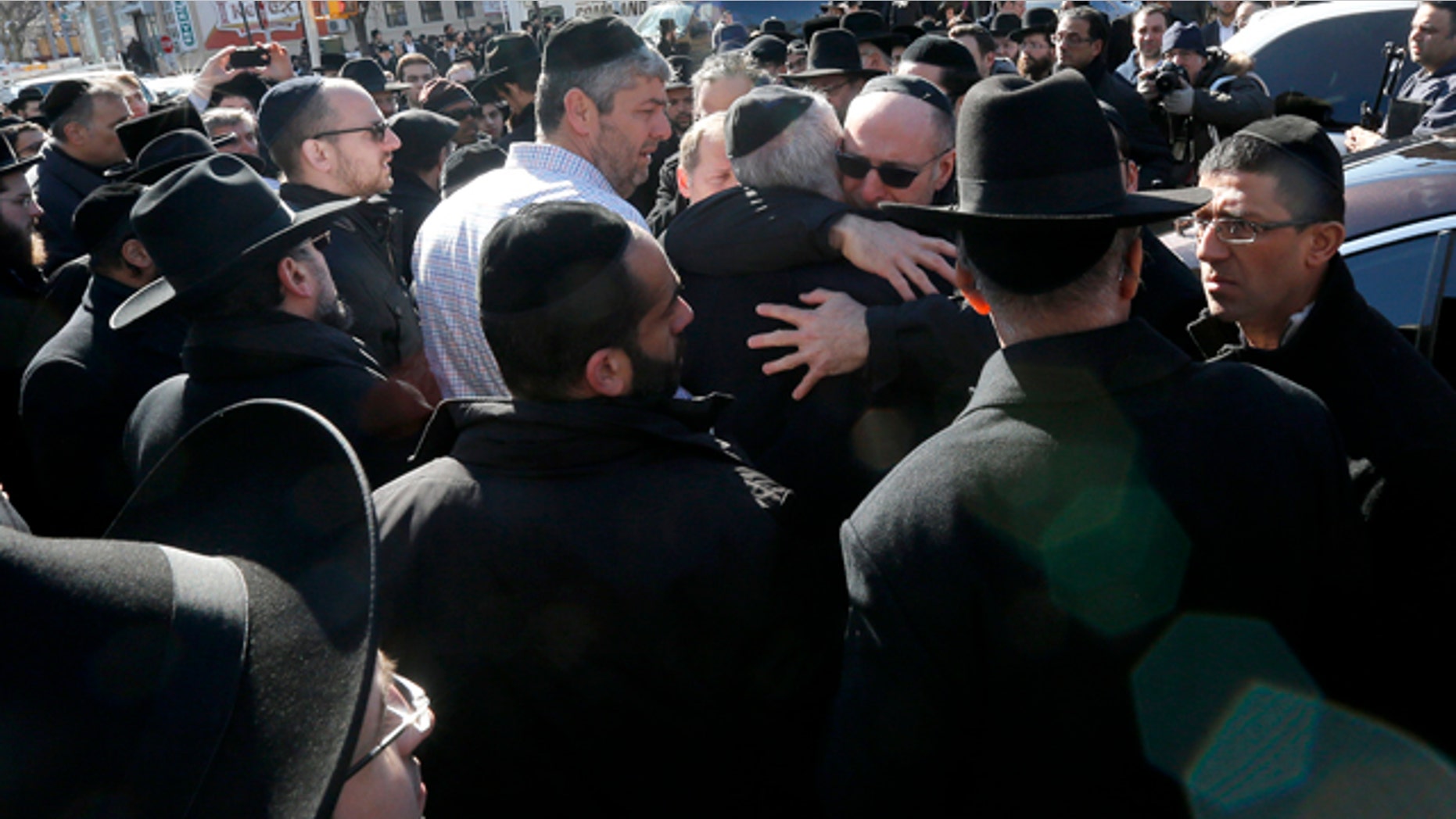 March 22, 2015: Mourners embrace each other after funeral services for seven siblings killed in a house fire in the Brooklyn borough of New York. (AP Photo/Julio Cortez)