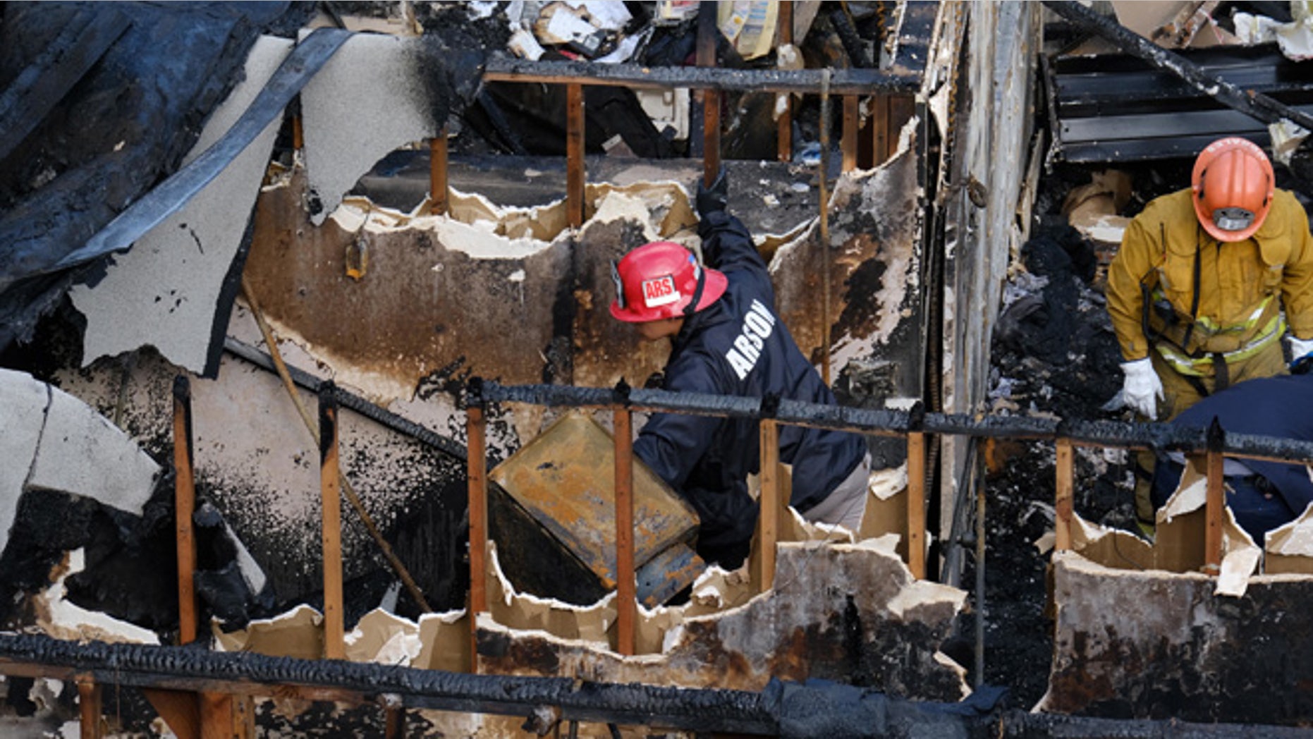 Los Angeles Fire Department arson investigators examine the burned-out ruins of an abandoned office building in the Westlake district just west of downtown Los Angeles Tuesday, June 14, 2016. Two men and two women were found Tuesday after a search using cadaver dogs, bringing the death toll to five. One person was found dead when the building burned Monday evening, June 13. Authorities believe the fire was intentionally set. (AP Photo/Richard Vogel)