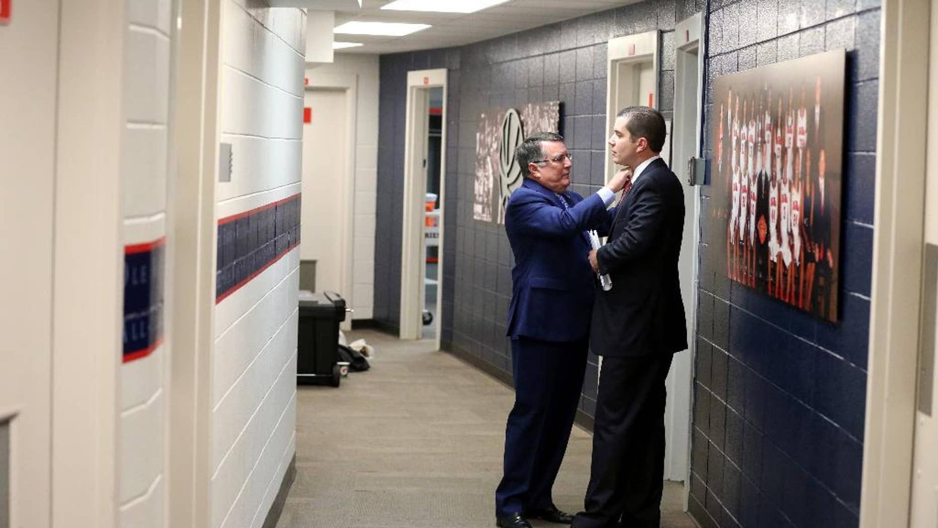 This Nov. 23, 2014, photo proved by The University of Mississippi Athletics Department shows Mississippi women's basketball coach Matt Insell, right and his father, Middle Tennessee State women's basketball coach Rick Insell, before their college basketball game in Oxford, Miss. The two coaches squared off in the first ever meeting between a father and son head coaches in NCAA Division 1 women's basketball history. (AP Photo/The University of Mississippi Athletics Department, Joshua McCoy)