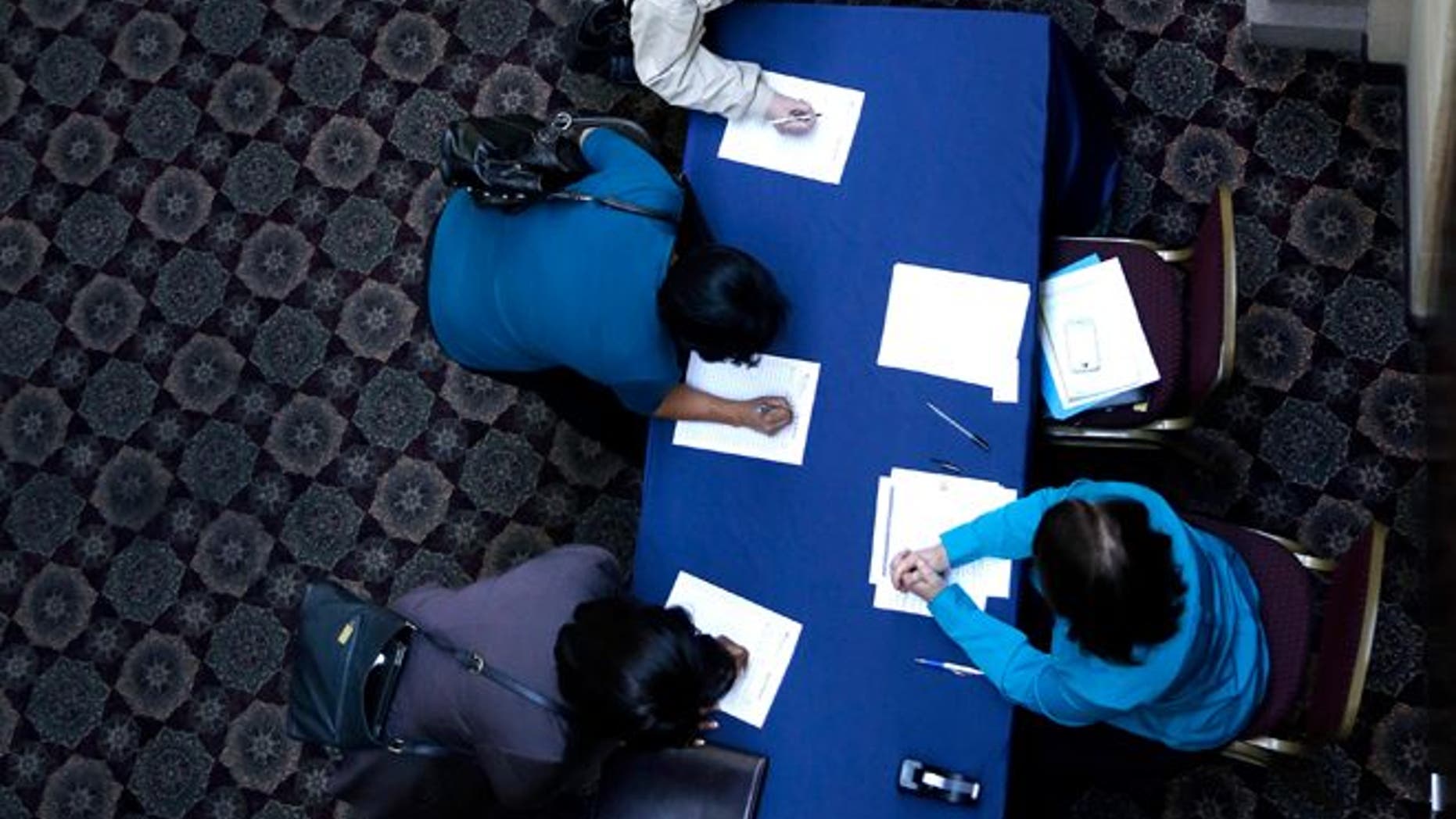 In this Wednesday, Jan. 22, 2014, photo, job seekers line up to sign in before meeting prospective employers at a career fair at a hotel in Dallas. The Labor Department releases employment data for February, on Friday, March, 7, 2014. (AP Photo/LM Otero)