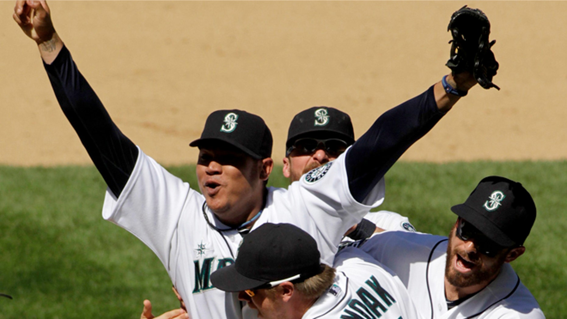 August 16: Seattle Mariners pitcher Felix Hernandez celebrates with teammates, including Justin Smoak (17), after throwing a perfect game. (AP Photo/The Seattle Times, Mark Harrison)
