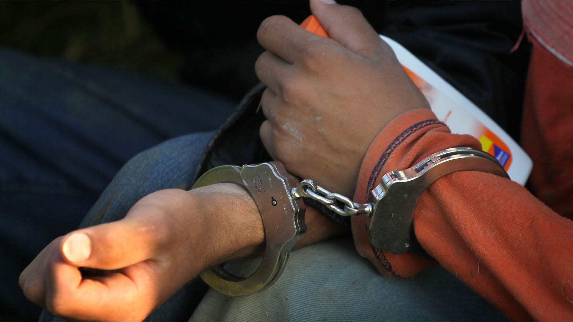 MCALLEN, TX - MAY 28: Undocumented immigrants sit handcuffed after being apprehended near the Mexican border May 28, 2010 near McAllen, Texas. They were captured with 25 others about one mile north of the Rio Grande River. During the 2009 fiscal year 540,865 undocumented immigrants were apprehended entering the United States along the Mexican border. (Photo by Scott Olson/Getty Images)