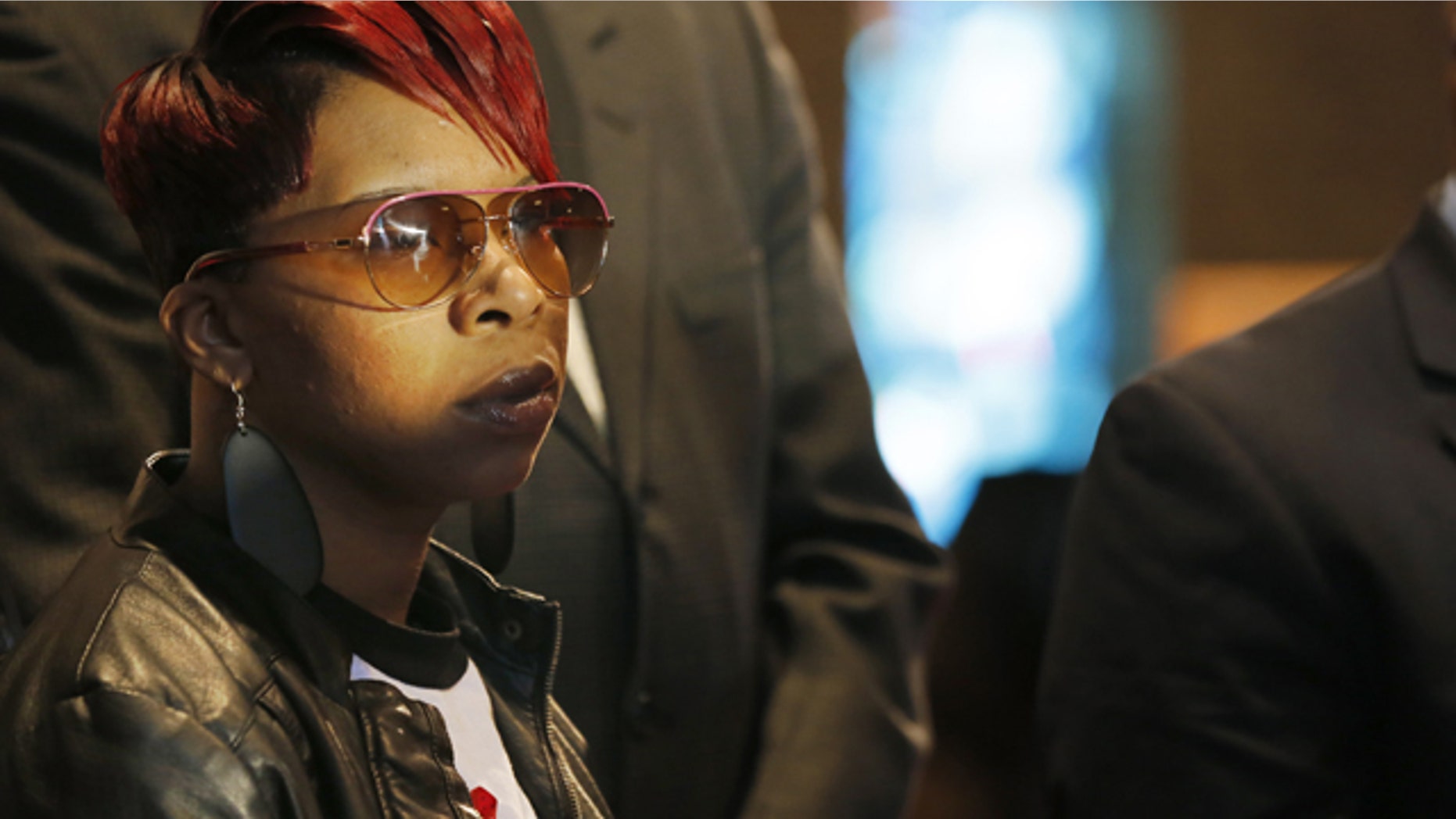 FILE - In this March 5, 2015, file photo, Lesley McSpadden, mother of Michael Brown Jr., listens to the family attorney during a news conference in Dellwood, Mo. Lawyers for the parents of Brown, the unarmed, black 18-year-old who was fatally shot by a white police officer in a St. Louis suburb, announced Wednesday, April 22, 2015, that they planned to file a civil lawsuit the following day against the city of Ferguson. (AP Photo/Charles Rex Arbogast, File)