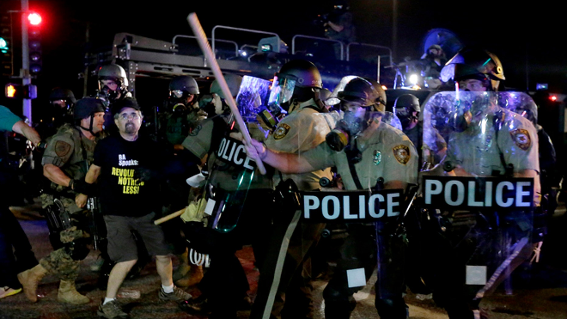 A man is detained after a standoff between protesters and police Monday, Aug. 18, 2014, during a protest for Michael Brown, who was killed by a police officer Aug. 9 in Ferguson, Mo. Brown's shooting has sparked more than a week of protests, riots and looting in the St. Louis suburb. (AP Photo/Charlie Riedel)