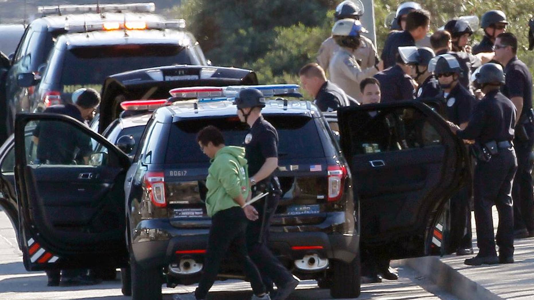 Nov. 26, 2014: A protestor is handcuffed and taken away by a police officer after the arrest of a small group of protesters who sat down in a bus lane alongside the U.S. 101.
