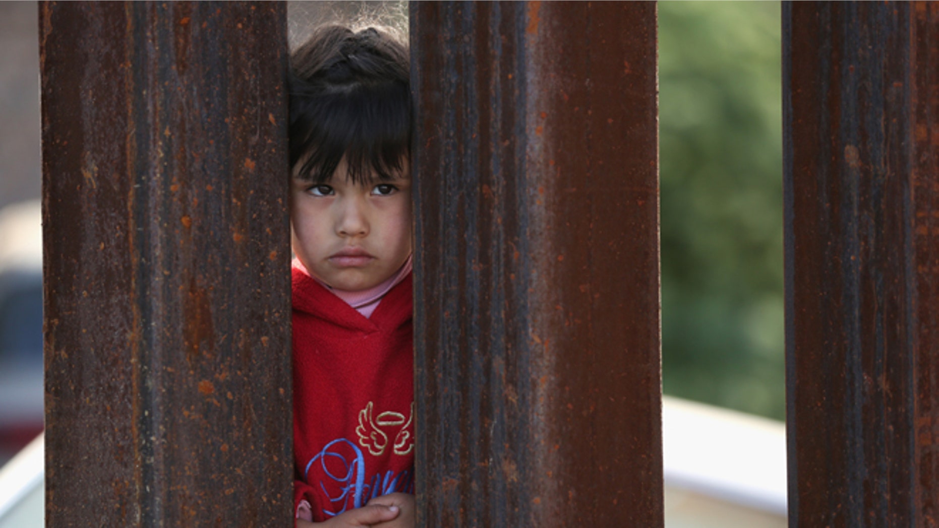 NOGALES, AZ - APRIL 01: A child on the Mexican side of the U.S.-Mexico border fence looks into Arizona during a special 'Mass on the Border' on April 1, 2014 in Nogales, Arizona. Catholic bishops led by the Archbishop of Boston Cardinal Sean O'Malley held the mass at the border fence to pray for comprehensive immigration reform and for those who have died along the border. (Photo by John Moore/Getty Images)