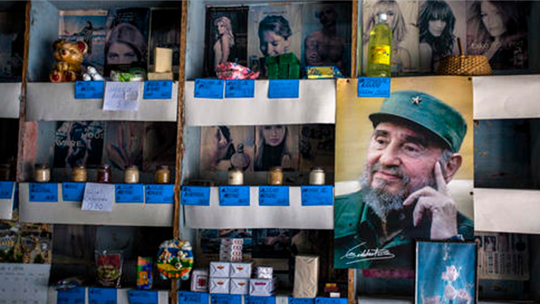 In this July 23, 2016 photo, a picture of Cuban Revolution leader Fidel Castro is placed on the shelves of a state rationing store or "bodega," ahead of his upcoming 90th birthday in Havana, Cuba. During 47 years in power, Fidel was a constant presence for Cubans but prohibited the statues, portraits and other tributes beloved by other total leaders. (AP Photo/Desmond Boylan)