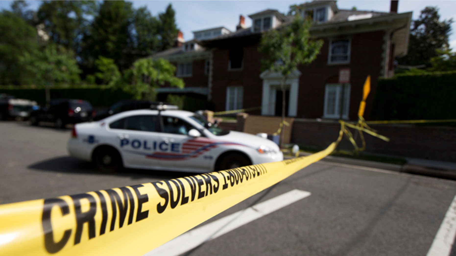Washington police secure the vicinity around the fire-damaged multimillion-dollar home in northwest Washington, Wednesday, May 20, 2015, where four people were found dead May 14. Washington Police Chief Cathy Lanier earlier identified two of the victims found dead as 46-year-old Savvas Savopoulos and his 47-year-old wife, Amy Savopoulos. Police believe the other two victims are the couple's 10-year-old son and a housekeeper. Police say the deaths are being investigated as a homicide. . (AP Photo/Manuel Balce Ceneta)