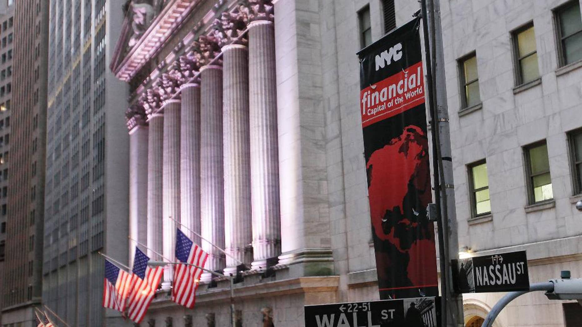 FILE - In this Wednesday, Oct. 8, 2014, file photo, a street sign for Wall Street hangs near the New York Stock Exchange. The government’s monthly jobs report fell just short of Wall Street’s expectations Friday, Nov. 7, 2014, leaving major stock market indexes to drift in midday trading. (AP Photo/Mark Lennihan, File)