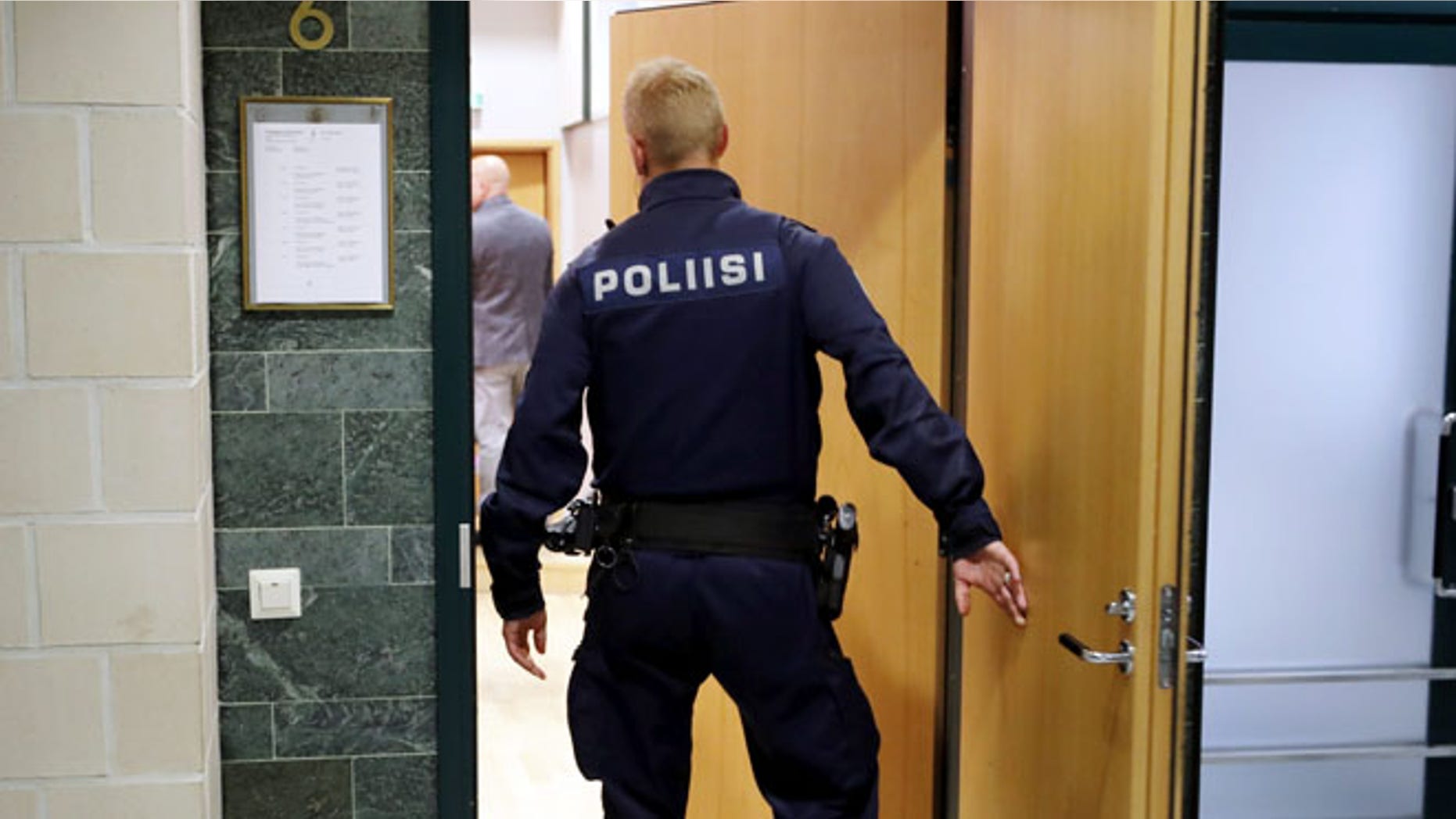 A police officer in Pirkanmaa district court in Tampere Finland, on Tuesday, July 5 2016. Finnish police have released two members of Cuba's national men's volleyball team but are holding six others on suspicion of aggravated rape, an investigator said Monday. (Kalle Parkkinen/Lehtikuva via AP)