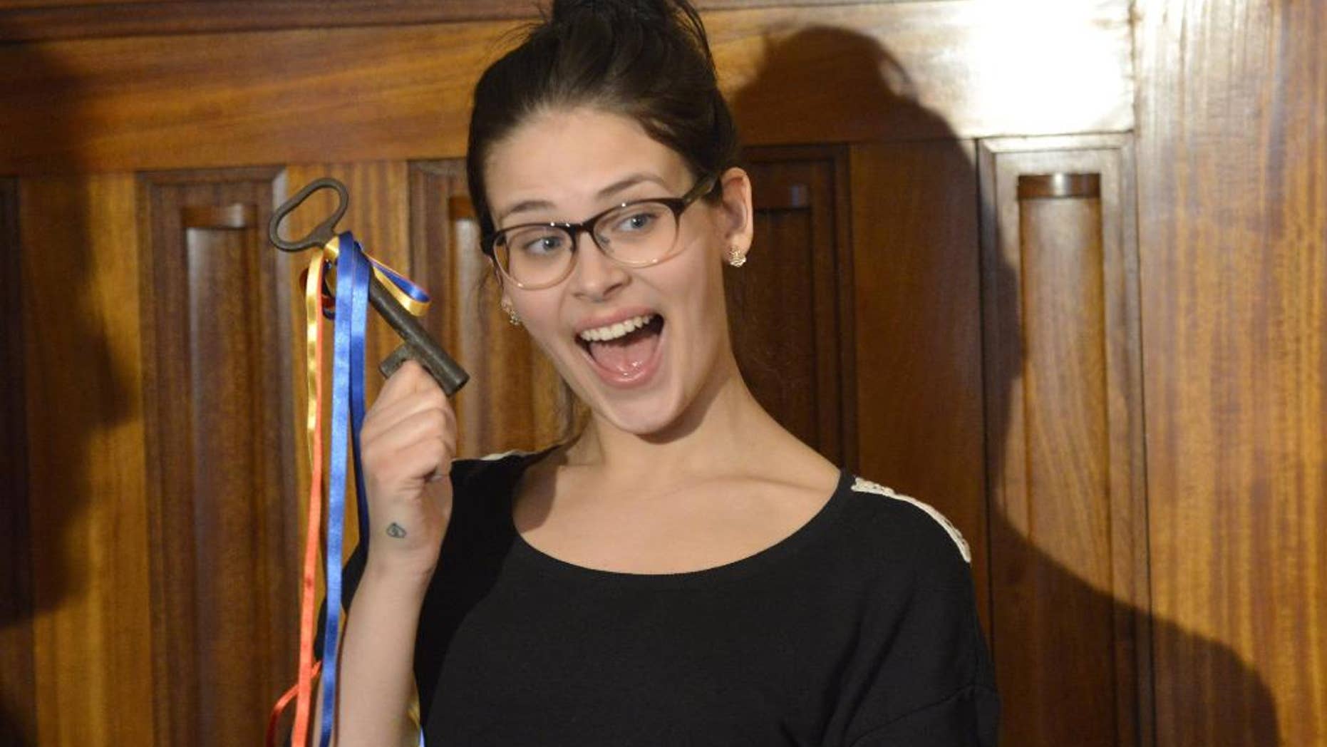Finnish 19-year old girl Sara Maria Forsberg, right, poses with the key to her home town at the Pietarsaari City Hall on Tuesday March 18, 2014, in symbolic recognition of her new found fame. Supermarket cashier Firsberg has more than 9 million views on her language imitation YouTube video "What languages sound like to a foreigner", and now she hopes her celebrity status will open new career opportunities for her. (AP Photo / LEHTIKUVA, Tomi Hirvinen) FINLAND OUT - NO SALES