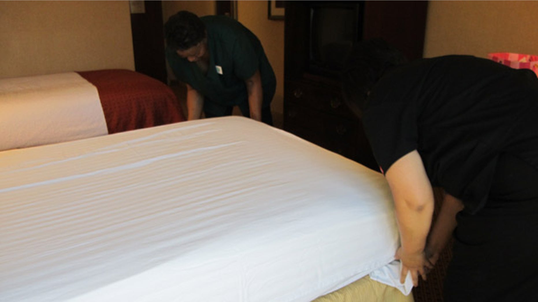Housekeepers make a bed at the Holiday Inn Fresno Airport.