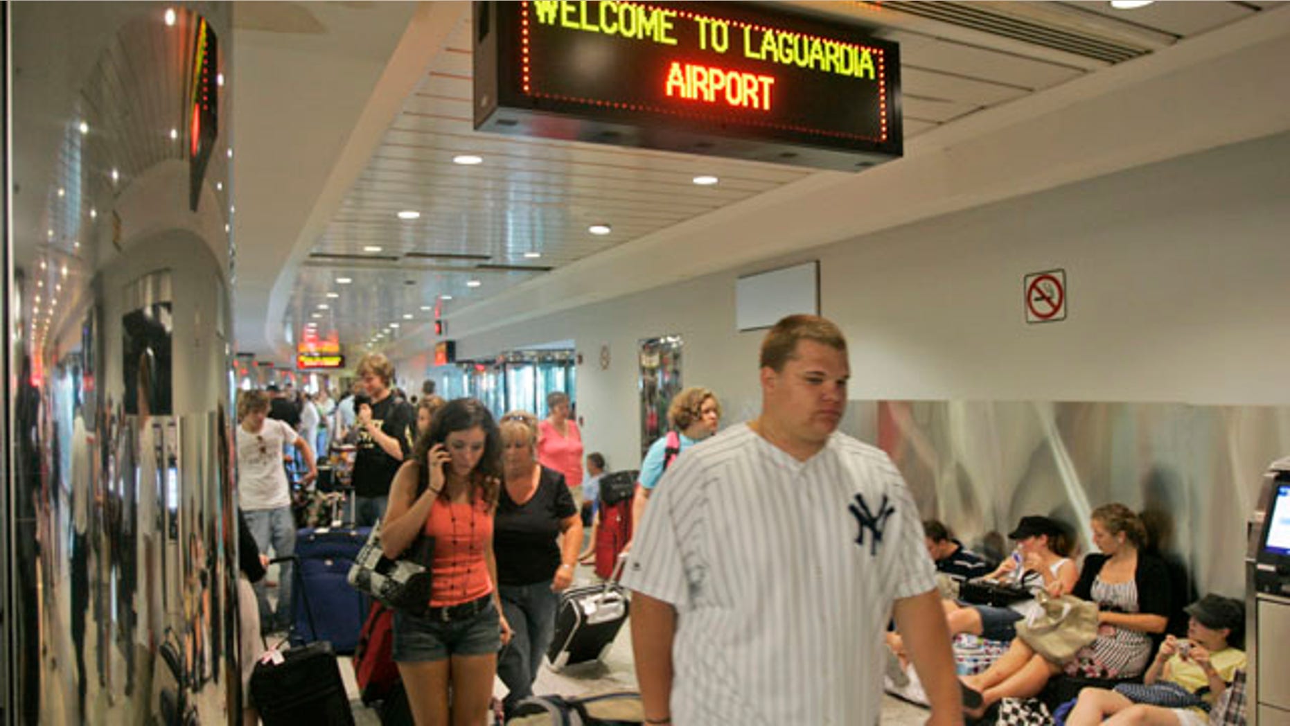 In this June 8, 2007 file photo, airline passengers navigate crowded walkways at LaGuardia Airport in New York.