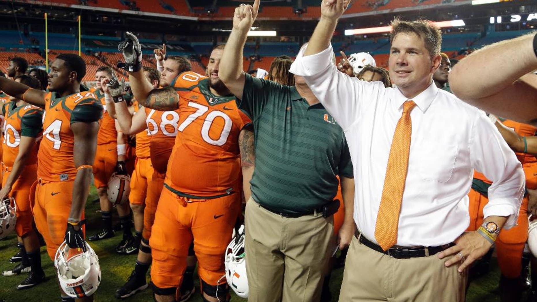Miami head coach Al Golden, right, sings the alma mater with the team after Miami defeated Florida A&M 41-7 in an NCAA football game, Saturday, Sept. 6, 2014, in Miami Gardens, Fla. (AP Photo/Lynne Sladky)