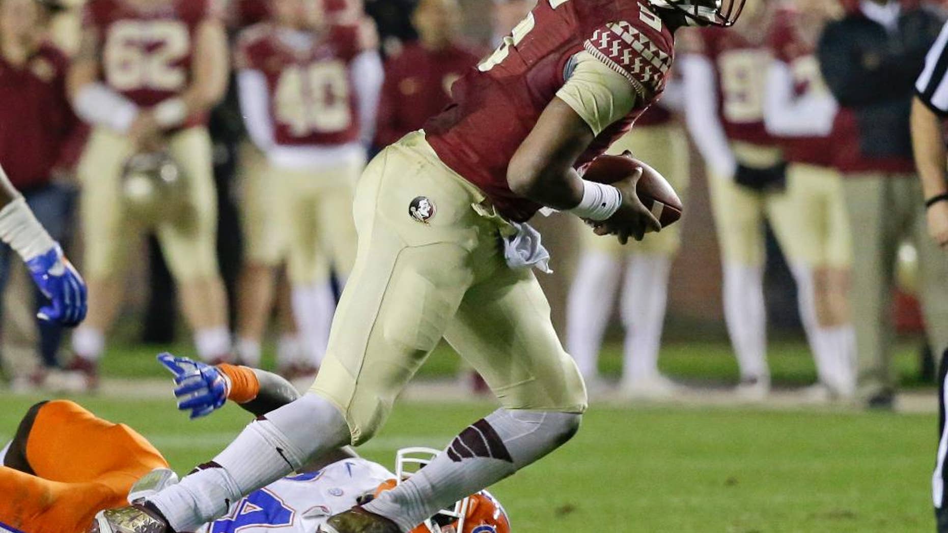 Florida State quarterback Jameis Winston scrambles out of the pocket as he is pressured by Florida defensive back Brian Poole during the second half of an NCAA college football game in Tallahassee, Fla., Saturday, Nov. 29, 2014. Florida State won 24-19. (AP Photo/John Raoux)