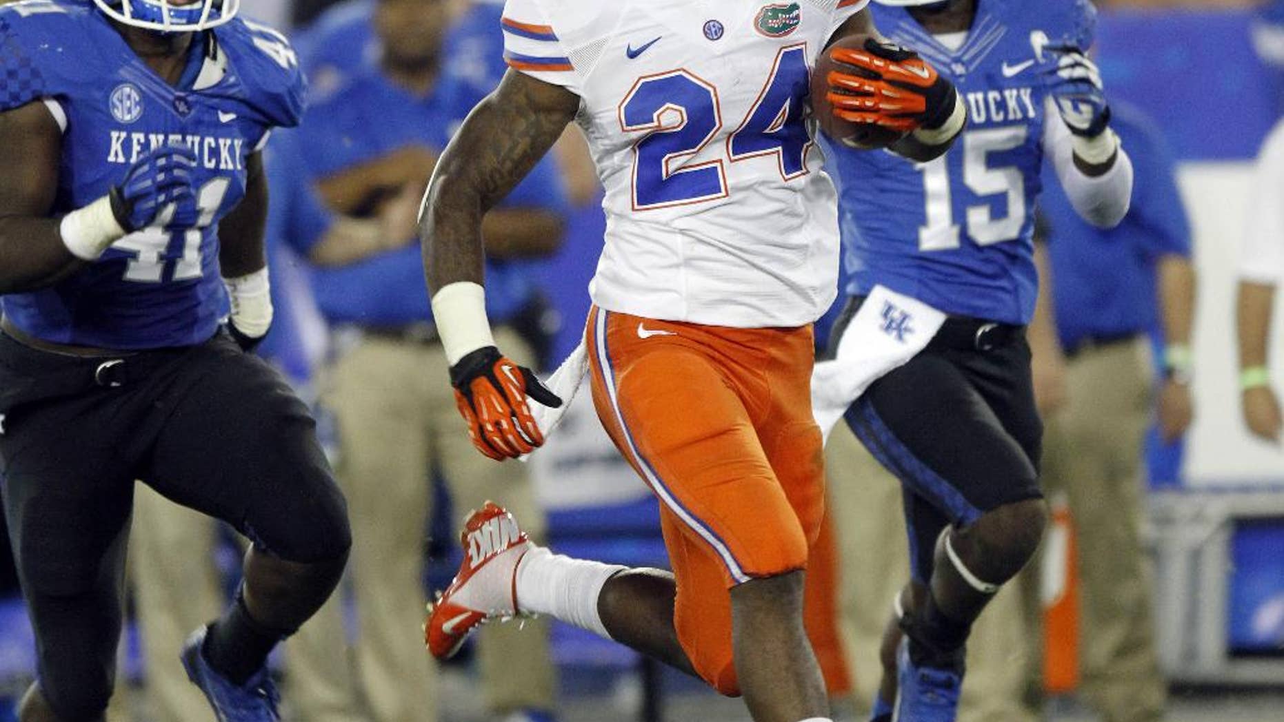 FILE - In this Sept. 28, 2013, file photo, Florida running back Matt Jones (24) outruns Kentucky's TraVaughn Paschal, left, and Marcus McWilson (15) in the second quarter of an NCAA college football game in Lexington, Ky. Jones was mostly miserable last season. He missed most of camp with a viral infection, rushed back and then blew out his knee early in the season. He's healthy now and eager to prove last year was a fluke. (AP Photo/James Crisp, File)