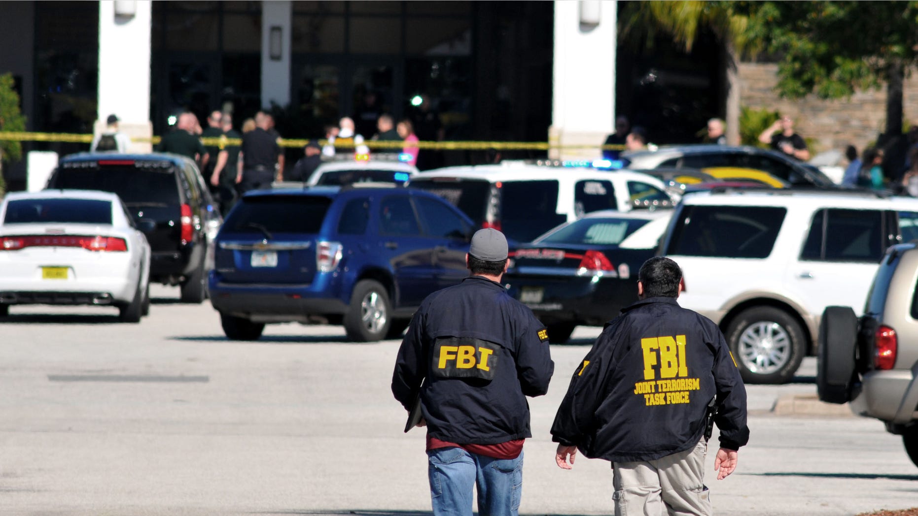 Law enforcement including the FBI respond to the scene of a shooting at the Melbourne Square Mall on Saturday, Jan 17, 2015 in Melbourne, Fla. Melbourne Police have confirmed that the shooting Saturday morning at the mall has left two people dead and one injured from a gunshot wound. Police say the injured victim is hospitalized in stable condition and cooperating with investigators. After responding to reports around 9:30 a.m. of multiple shots fired inside the mall, police tweeted that the "shooter is contained." (AP Photo/Florida Today, Malcolm Denemark) NO SALES