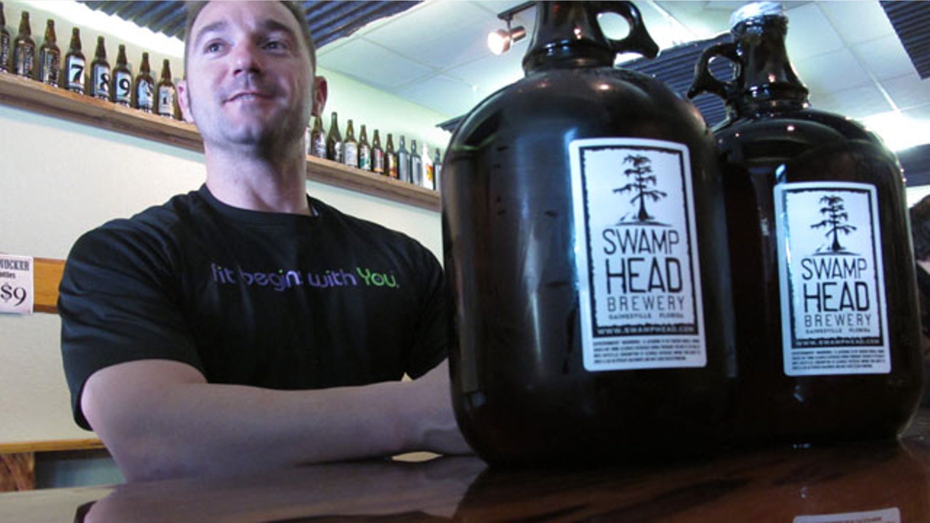 Mar. 29, 2013: Patron Adam Rudell, of St. Petersburg, Fla., sits with two gallon-sized jugs of beer, known among beer enthusiasts as growlers, at the Swamp Head Brewery in Gainesville, Fla.
