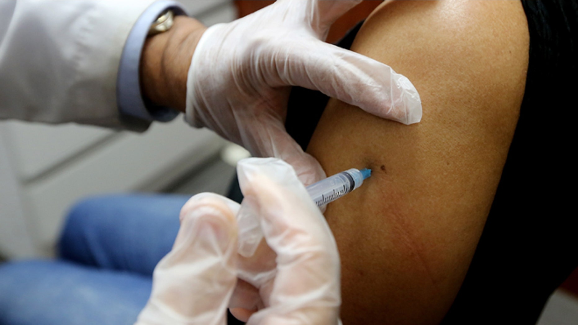 NEW YORK, NY - JANUARY 14: Phamacist Prakash Deshpande injects a patient with influenza vaccine at a Manhattan pharmacy on January 14, 2013 in New York City. The state of New York has declared a public health emergency in a flu epidemic of more than 19,000 confirmed cases in the state. (Photo by Mario Tama/Getty Images)