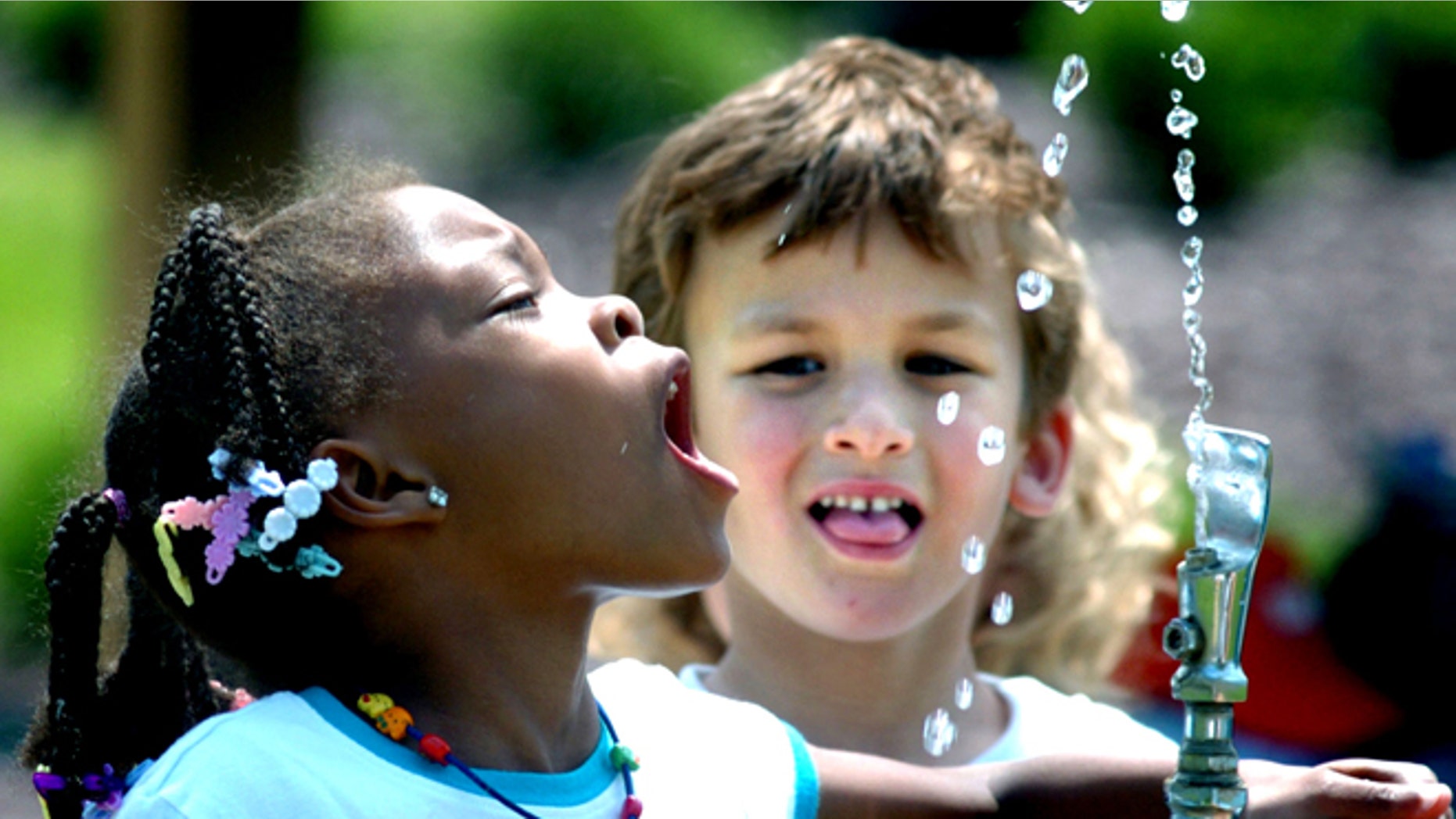 June 3, 2008: In this file photo, Tianna Swisher, a student at Liberty Valley Elementary School in Danville, Pa., attempts to drink from the water fountain at Montour Preserve near Washingtonville, Pa., during an outdoor field trip.