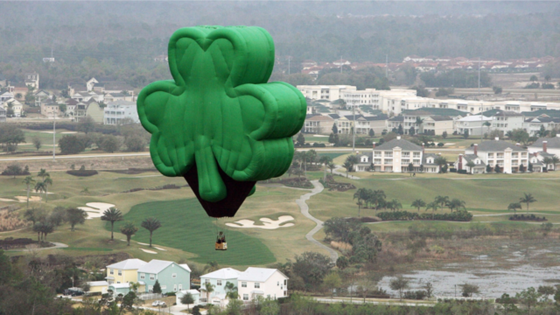 A green shamrock hot-air balloon, named "Paddy" and flown by Orlando Balloon Rides, drifts over Florida on St. Patrick's Day.