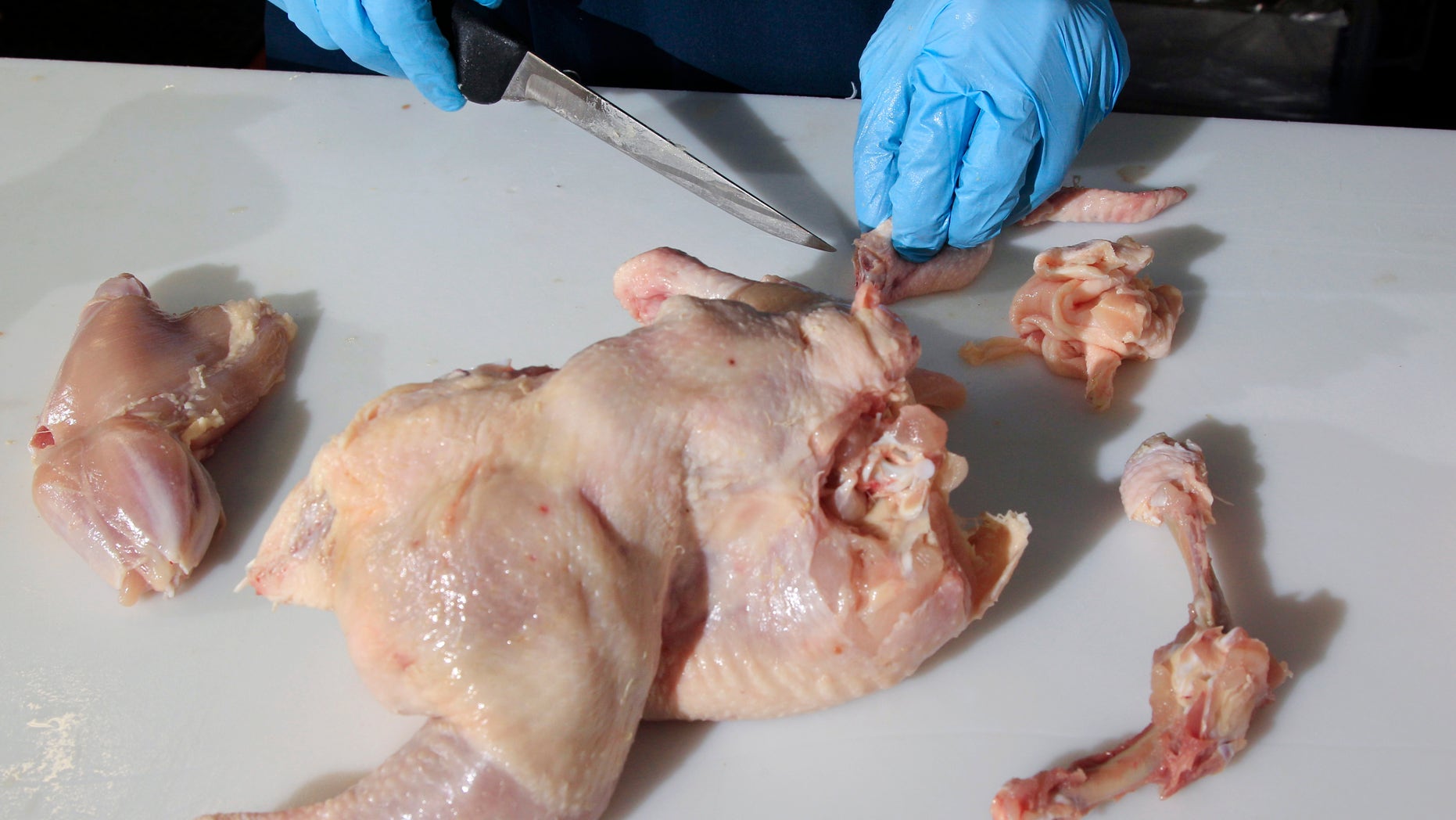In this April 26, 2012 photo, Pat LaFrieda Jr., whose business is featured on the new Food Network show "Meat Men," trims dark meat from a chicken at his company, Pat LaFrieda Meat Purveyors, in North Bergen, N.J. Thighs and drumsticks are climbing the pecking order as Americans join consumers abroad in seeking out flavor thats lacking in the boneless, skinless chicken breasts that have long dominated the domestic market. While the poultry industry once had trouble finding markets for dark meat, sales are now growing rapidly. (AP Photo/Mel Evans)