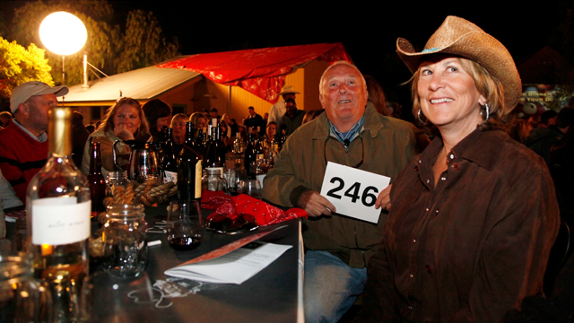 This Aug. 28, 2010 photo shows Dan Duckhorn, second from right, chairman and founder of the Duckhorn Wine Company and his wife Nancy Andrus Duckhorn, right, board member of Napa Valley Grapegrowers, as they watch people bid during an auction at the grapegrowers STOMP harvest dinner at Hudson Vineyards in Napa, Calif. STOMP is an authentic food and wine celebration and gathering for Napa Valley wine enthusiasts to celebrate the imminent harvest season. (AP Photo/Eric Risberg)