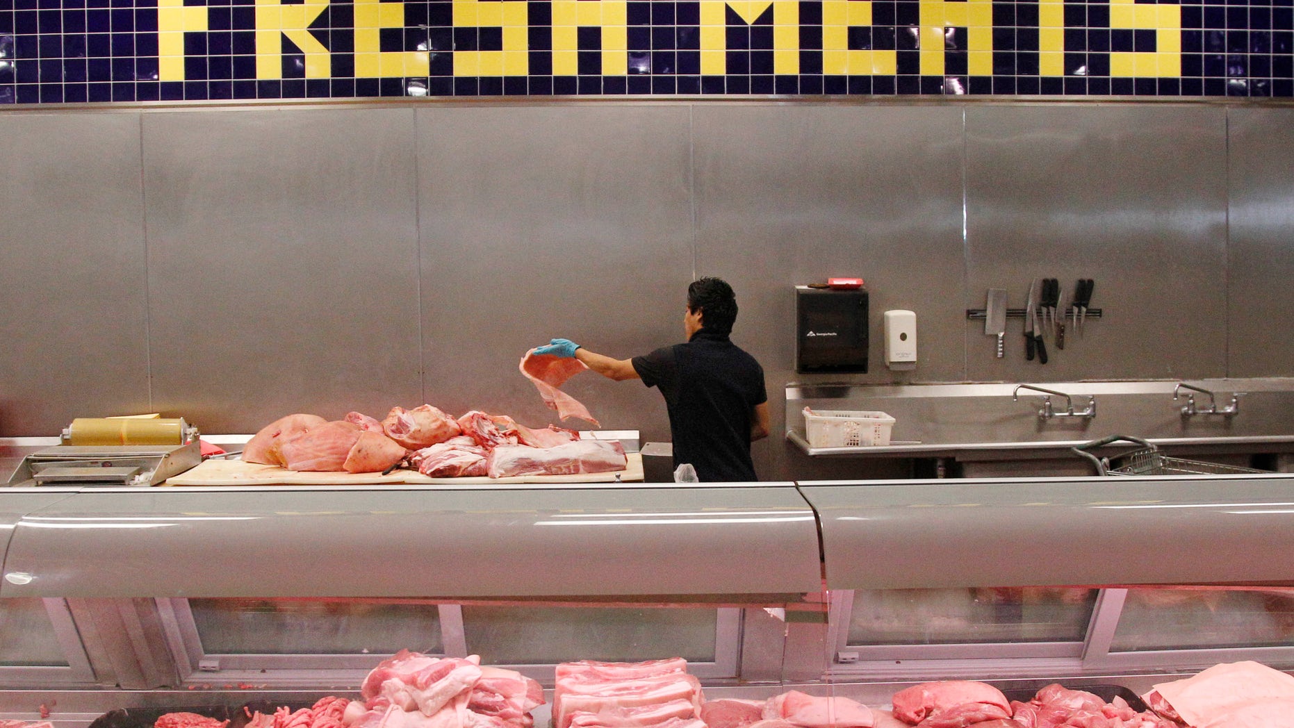 July 25, 2012: In this file photo butcher Freddie Quina cuts meat at Super Cao Nguyen in Oklahoma City.