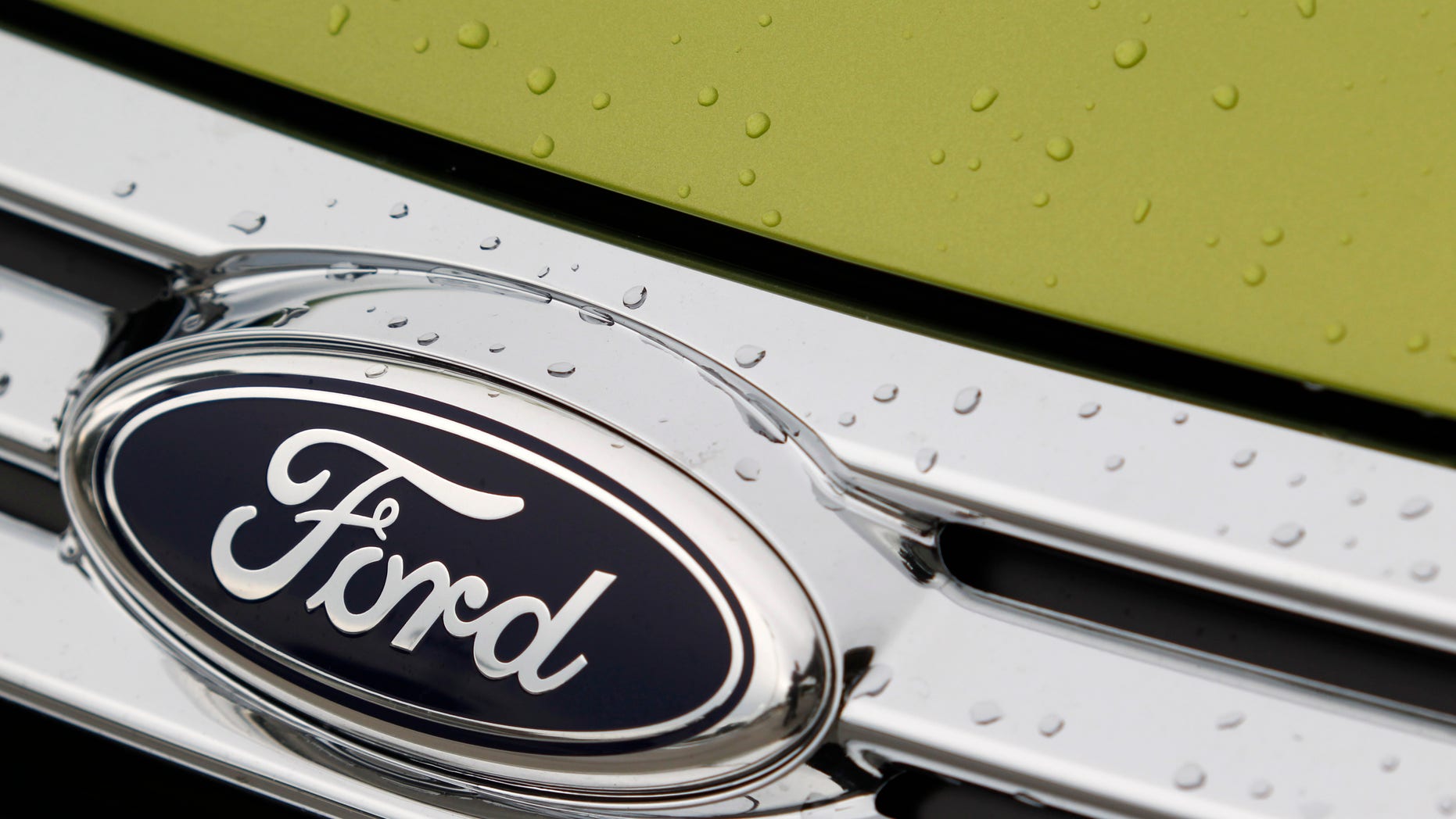 This Aug. 31, 2011 photo, shows raindrops on the grill of a Lime Squeeze Metallic 2012 Ford Fiesta SE at the Maroone Ford of Miami dealership. Ford Motor Co. and the United Auto Workers have come to terms on a new four-year contract Tuesday, Oct. 4, 2011, that trades annual pay raises for profit sharing and a signing bonus and promises thousands of new jobs building cars and trucks. (AP Photo/Wilfredo Lee)