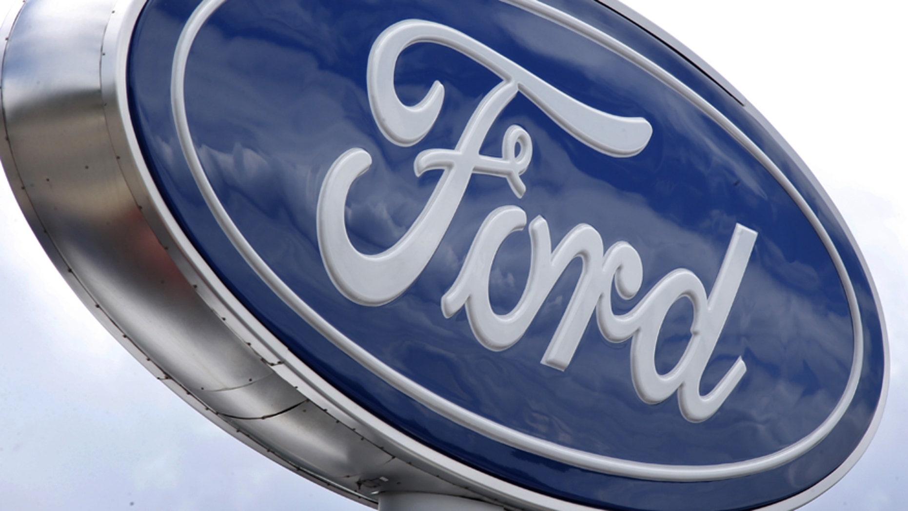 FILE - In this Thursday, June 5, 2014, file photo, clouds are reflected in the Ford sign at a dealership in Wexford, Pa. U.S. safety regulators have closed an investigation into steering problems in more than 500,000 Ford full-size cars without seeking a recall, the company announced Tuesday, Nov. 25, 2014. (AP Photo/Keith Srakocic, File)