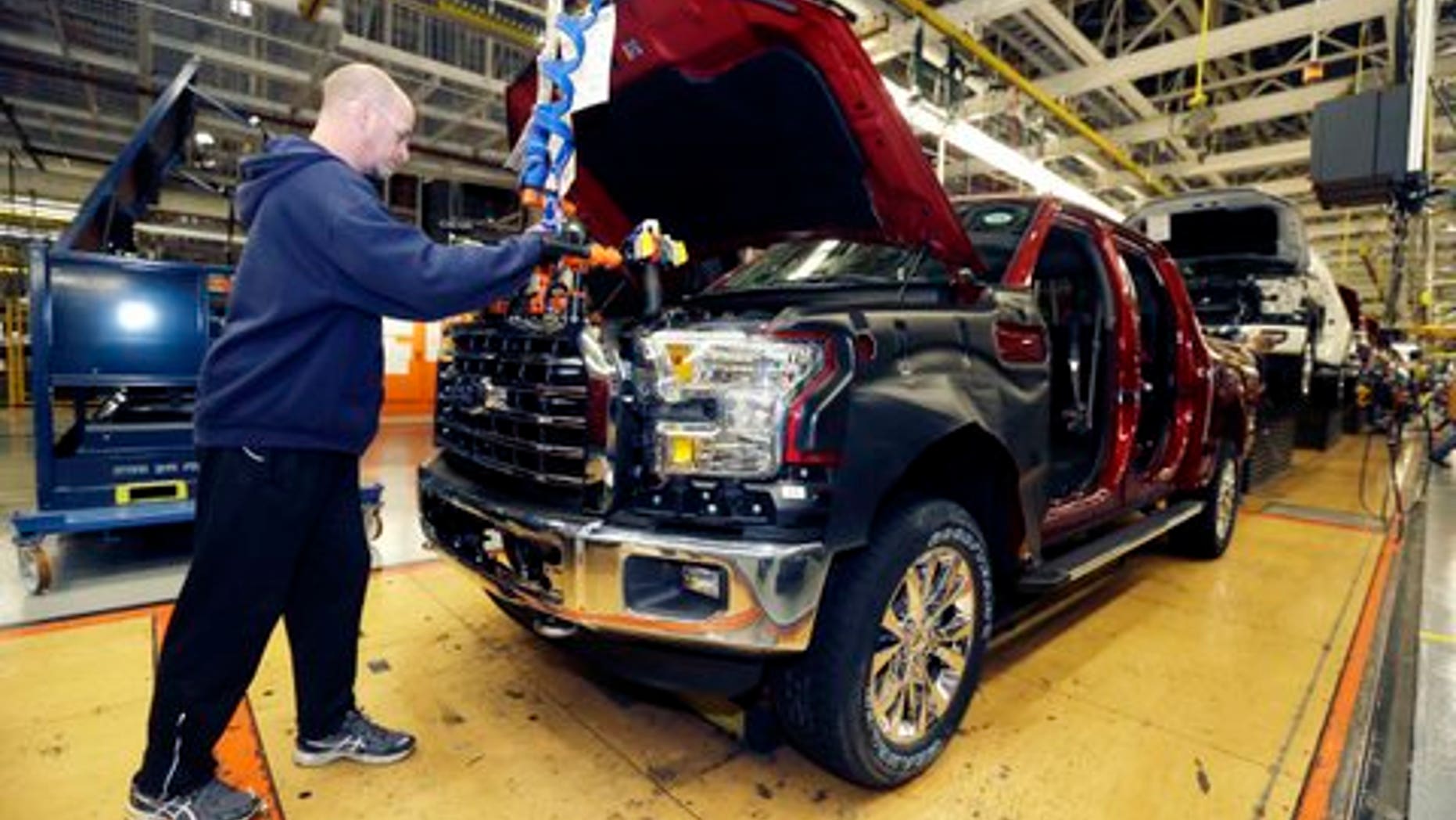 In this Nov. 6, 2014 photo, Chris Lucking installs a grill on a new Ford F-150 truck at the Dearborn Truck Plant in Dearborn, Mich. ItÃs Ford Motor Co.Ãs biggest bet in decades: an aluminum-sided F-150 that could set a new industry standard _ or cost the company its pickup truck crown. (AP Photo/Carlos Osorio)
