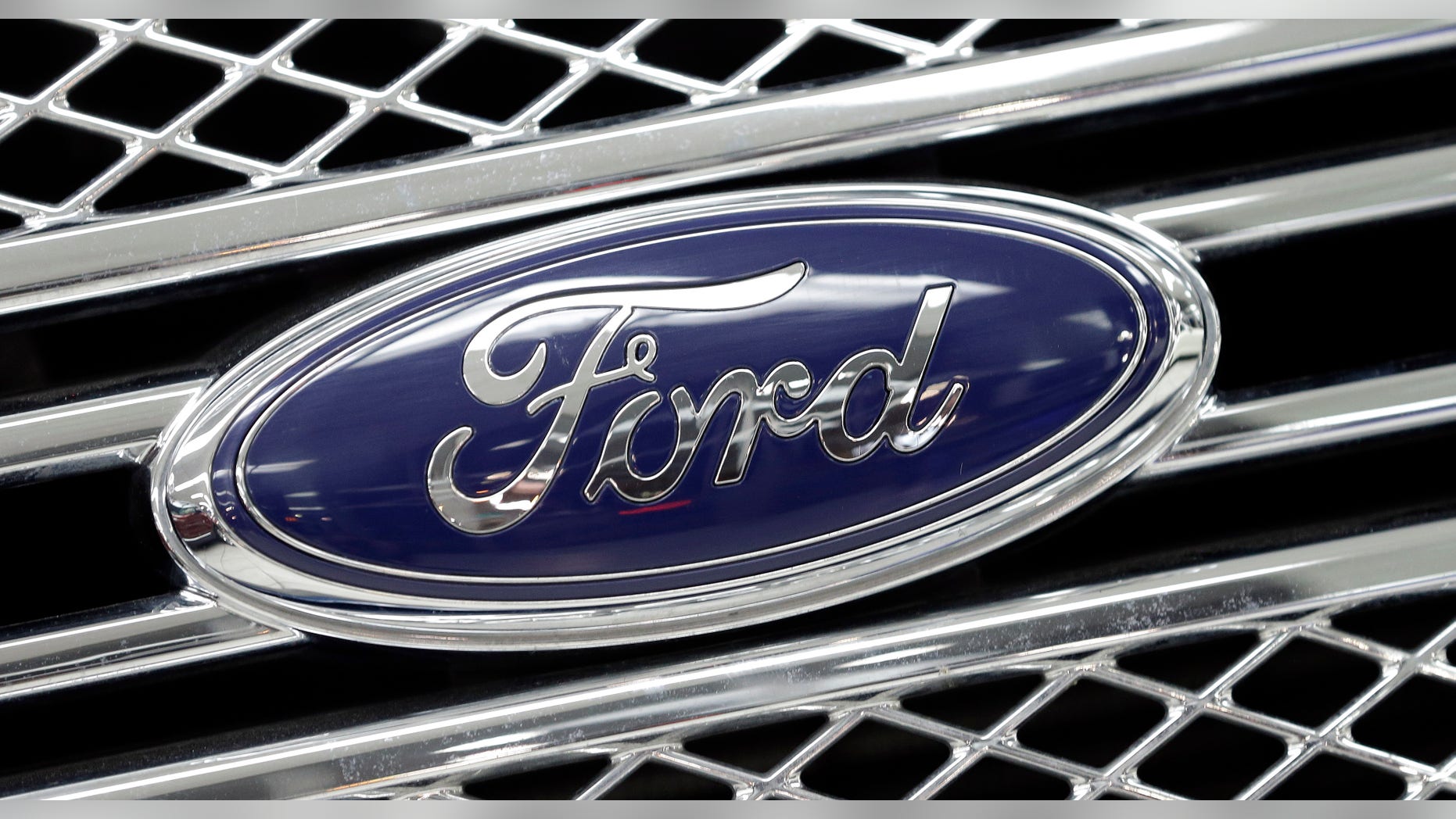 FILE - In this Jan. 5, 2015, file photo, the Ford logo shines on the front grille of a 2014 Ford F-150, on display at a local dealership in Hialeah, Fla. Ford will build a new $1.6 billion factory in Mexico, creating about 2,800 jobs and shifting small-car production from the U.S. The announcement Tuesday, April 5, 2016 comes at a time when moving jobs to the south has become a major issue in the U.S. presidential campaign. (AP Photo/Alan Diaz, File)