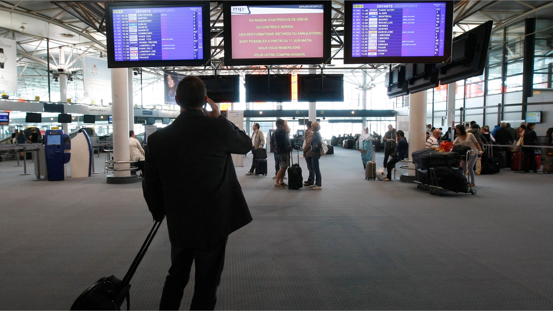 Passengers check flight information at Marseille-Provence Airport, in Marignane, southern France, Tuesday, June 11, 2013.