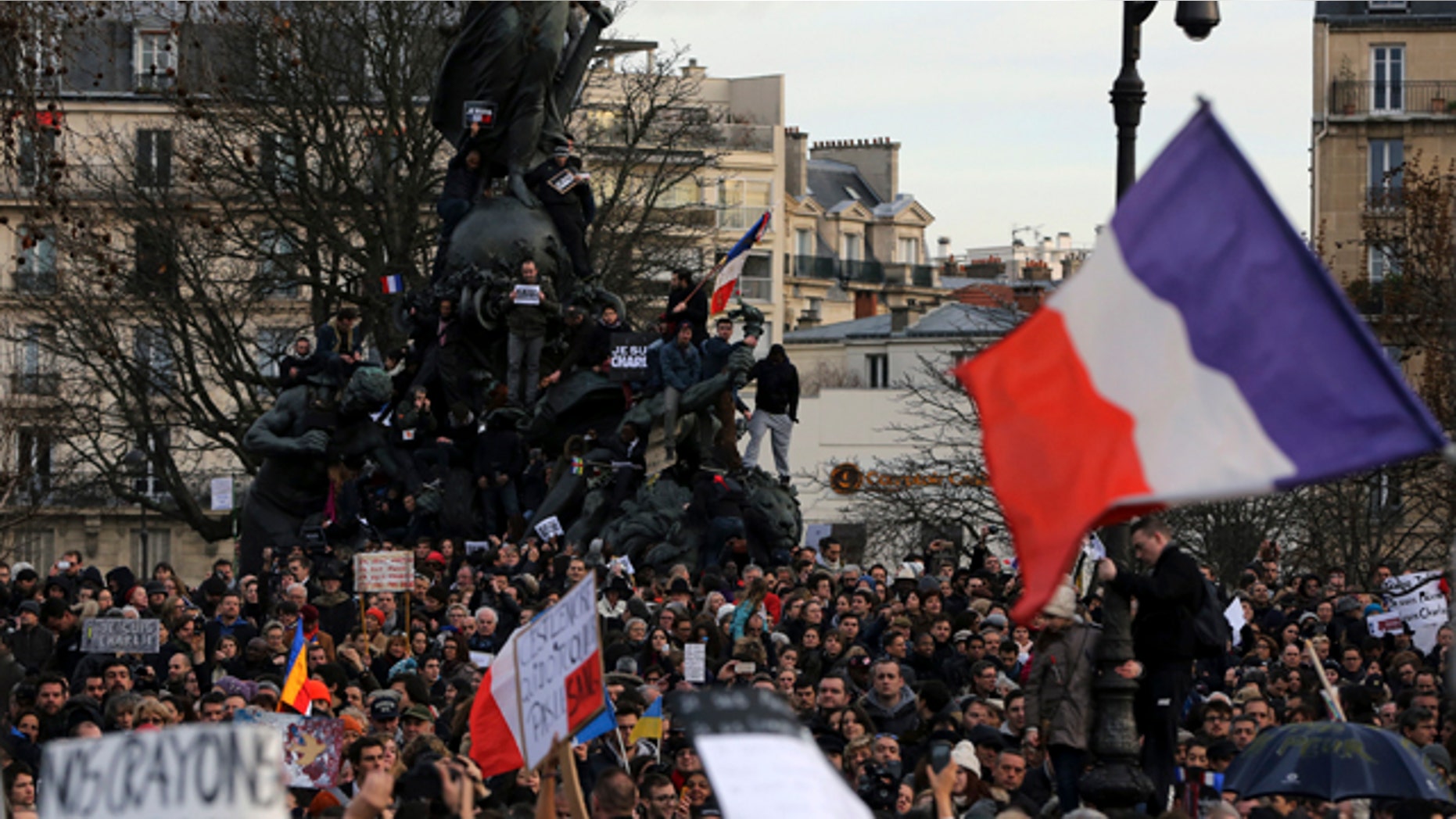 Jan. 11, 2015: People wave national flags and hold placards that read 'I am Charlie' at the Place de la Nation in Paris. (AP Photo/Burhan Ozbilici)