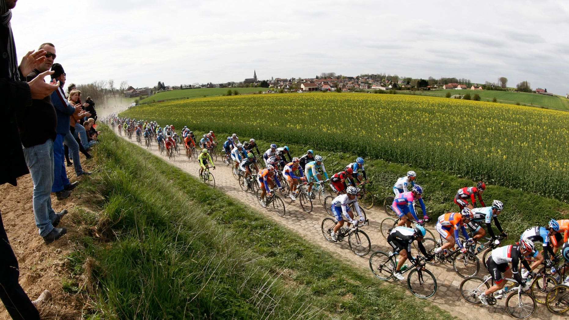 Riders cycle on a cobblestone-paved section of road during the classic cycling race Paris-Roubaix in Troisvilles , northern France, Sunday April 8, 2012. (AP Photo/Michel Spingler).