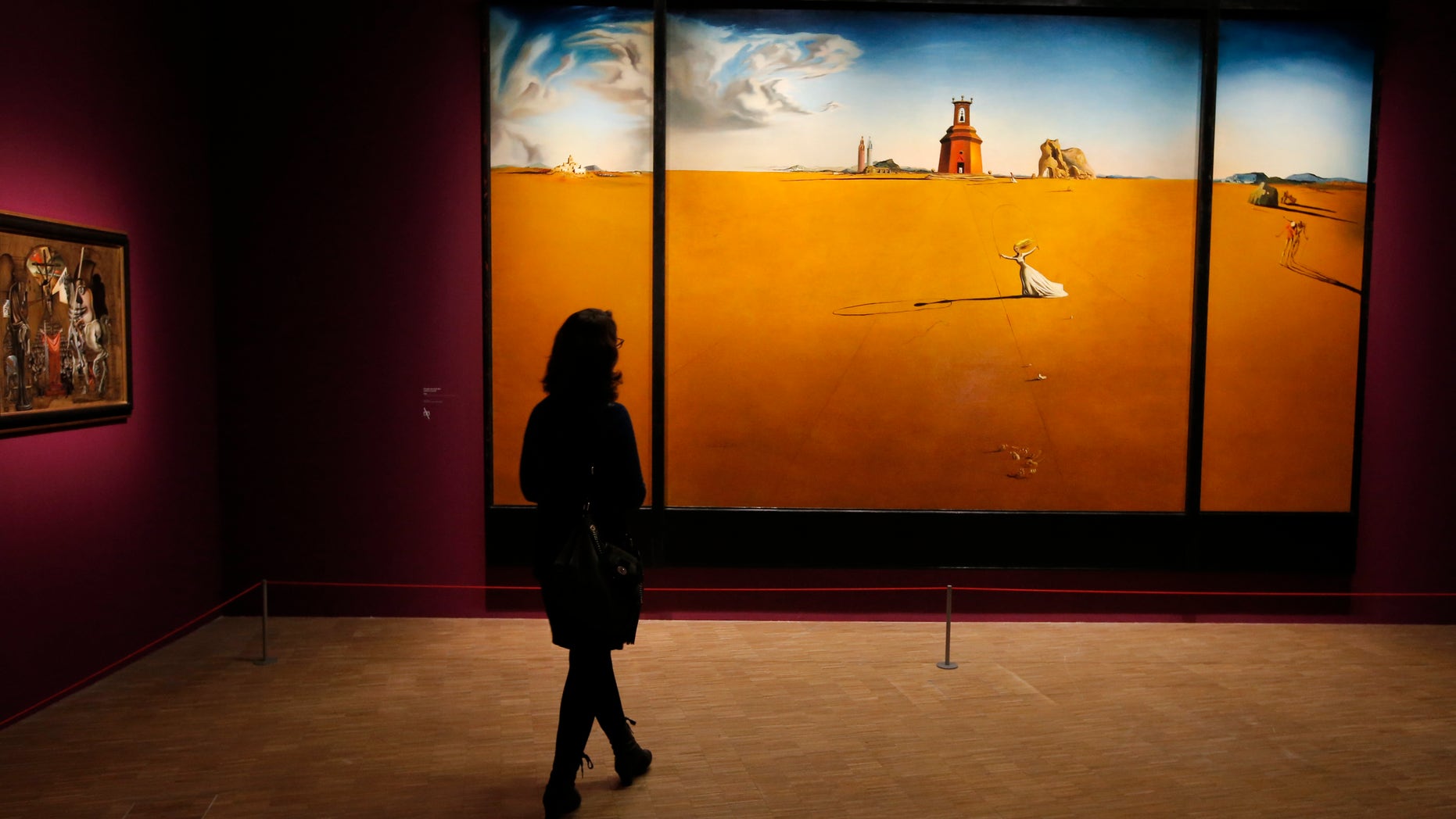 In this photo taken Monday Nov. 19, 2012, a women looks at a painting by Spanish artist Salvador Dali (1904-1989) during the presentation to the press of the exhibition "Dali" at the Centre Pompidou modern art museum, in Paris.