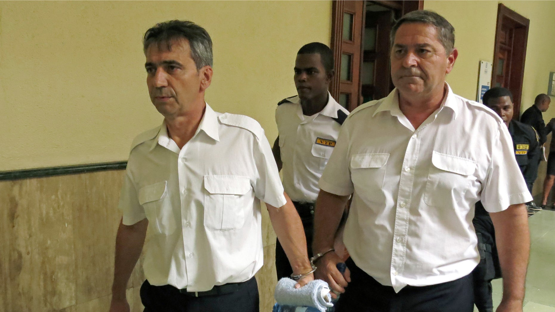 FILE - In this June 17, 2014 file photo, French pilots Bruno Odos, left, and Pascal Jean Fauret, who have been formally charged with drug trafficking, are escorted to a courtroom in Santo Domingo, Dominican Republic (AP Photo/Ezequiel Abiu Lopez, File)