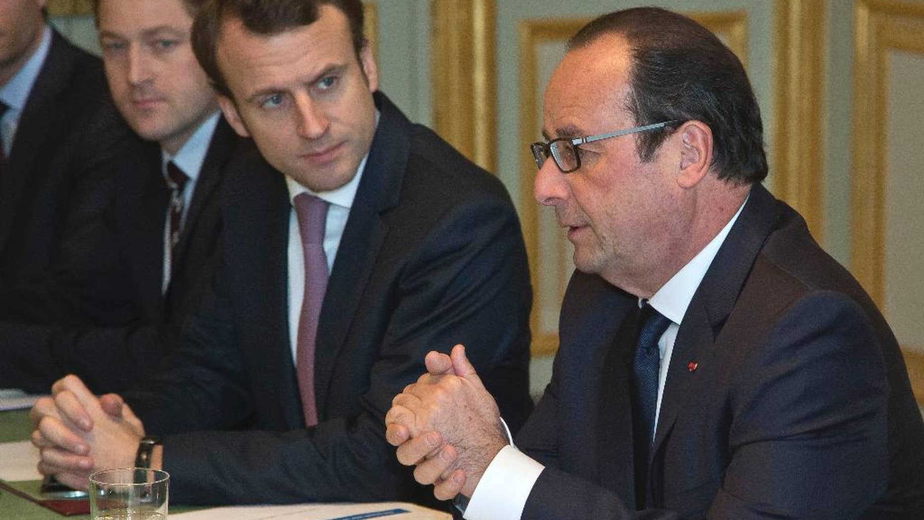 France's President Francois Hollande, right, and Economy Minister Emmanuel Macron, meet oil industry group leaders, on gasoline prices, at the Elysee Palace in Paris, Monday, Dec. 8, 2014. (AP Photo/Michel Euler, Pool)