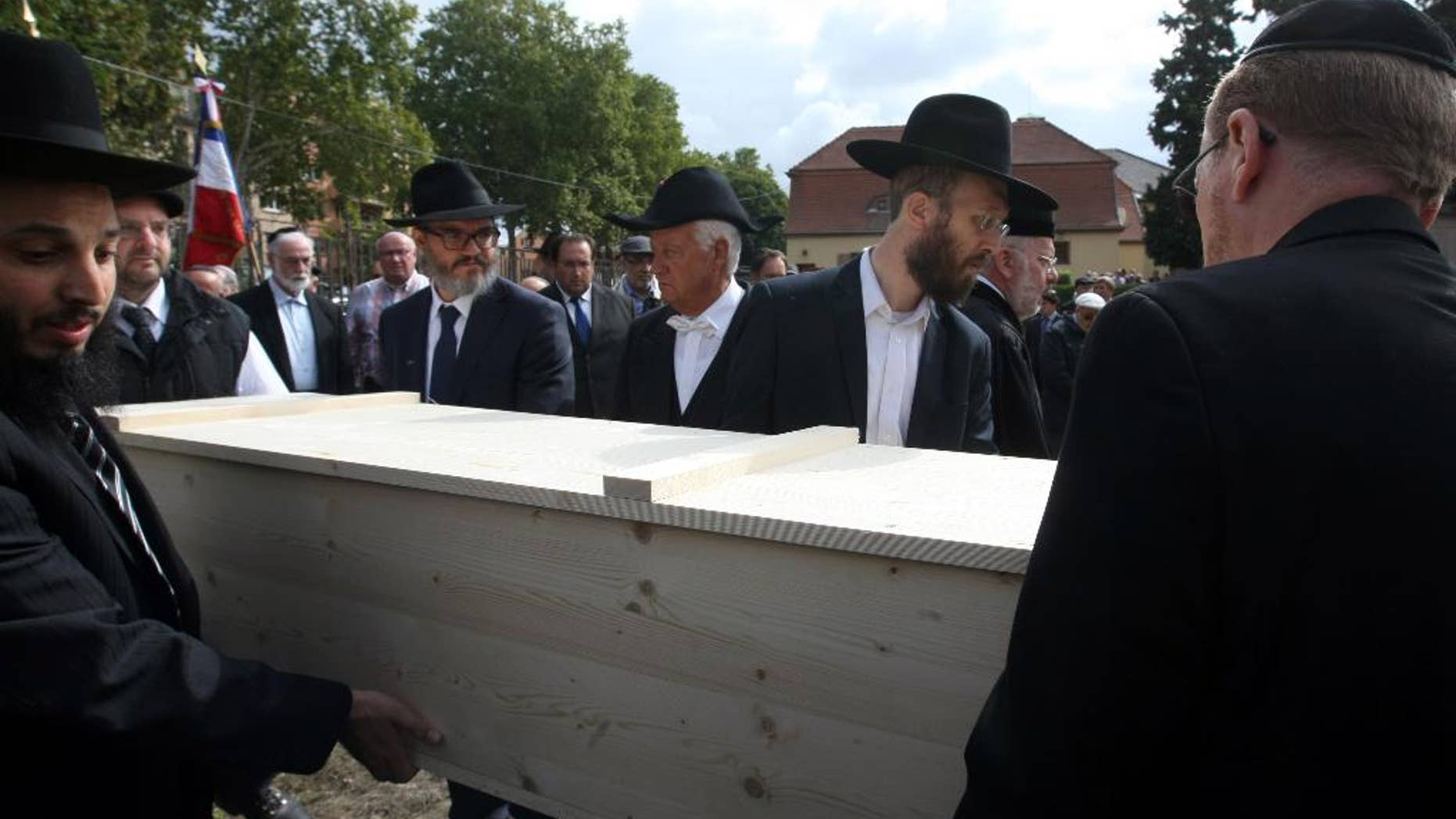 Members of the Jewish community of Strasbourg carry a coffin bearing the remains of a Jewish victim of Nazi anatomist August Hirt, during a ceremony at the Jewish cemetery of Cronenbourg, eastern France, Sunday, Sept. 6, 2015. The remains of Holocaust victims kept for decades in a French medical school were laid to rest on Sunday. (AP Photo/Christian Lutz)
