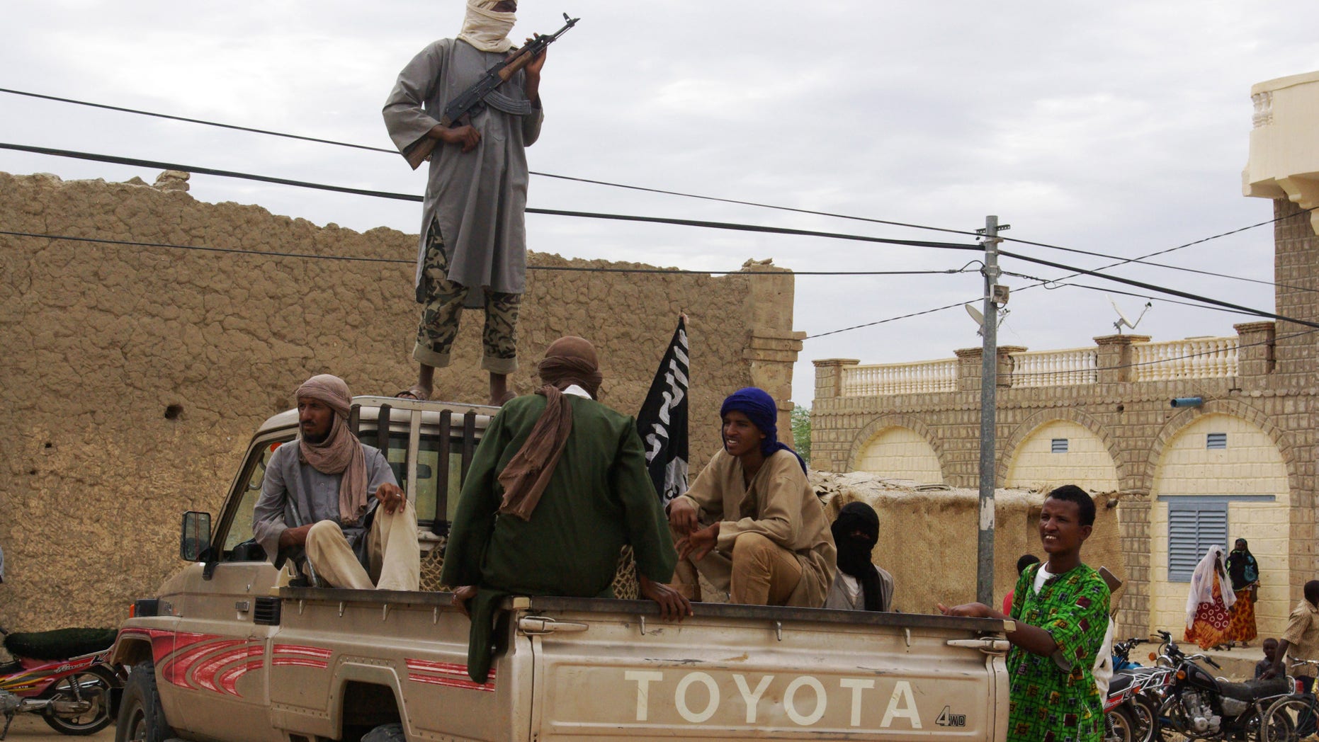 FILE - In this Aug. 31, 2012 file photo, fighters from Islamist group Ansar Dine stand guard in Timbuktu, Mali, as they prepare to publicly lash a member of the Islamic Police found guilty of adultery. France is moving surveillance drones to western Africa amid rising concerns that an al-Qaida offshoot and its allies who control northeast Mali represent a major threat to French interests abroad _ and possibly at home. With six French hostages held by Islamic militants in the region, France is facing a delicate task, but has garnered support from other Western powers including the United States to keep Mali from becoming a new launchpad for global terrorism. (AP Photo, File)