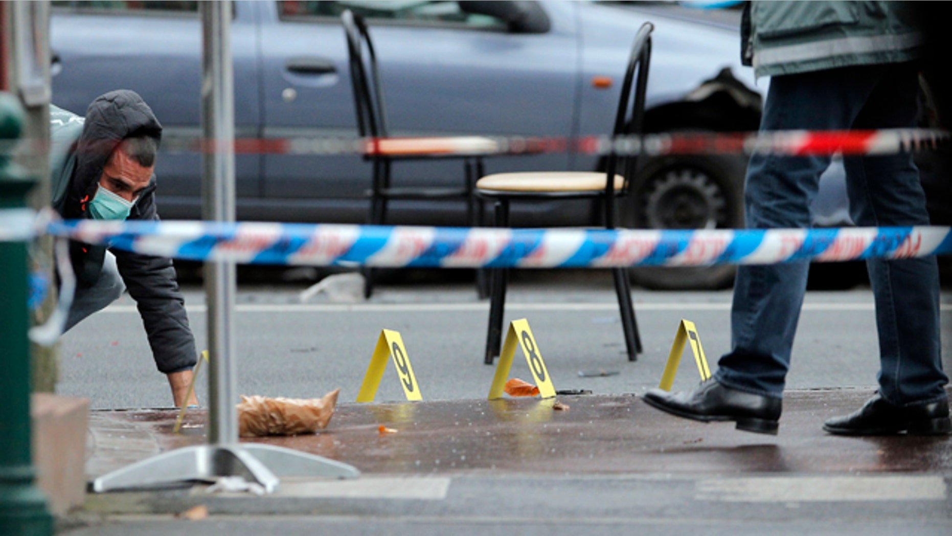 Jan. 8, 2015: Police officers look for evidence after a shooting in Montrouge, outside Paris. A police union official said that a female officer died of wounds sustained when she was shot while investigating a traffic accident. (AP Photo/Christophe Ena)