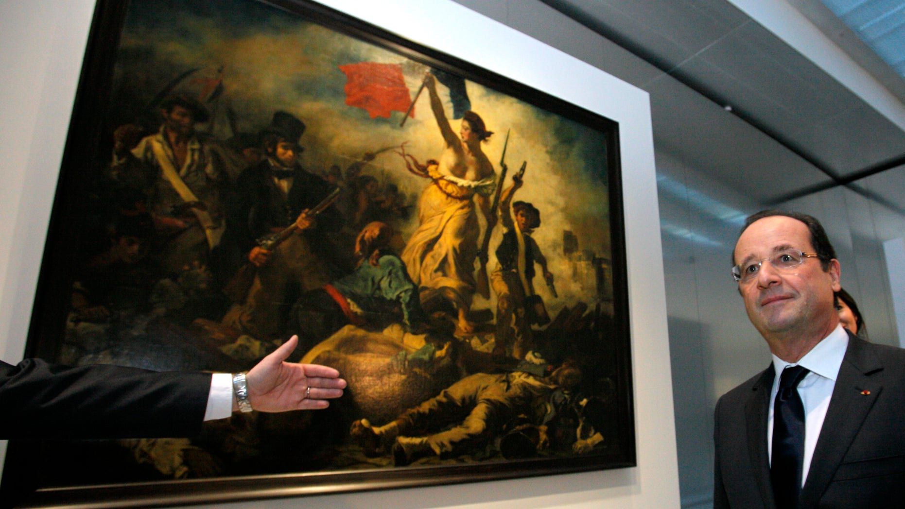 Dec. 4, 2012 - FILE photo shows French Pres. Francois Hollande in front of "Liberty Leading the People," a painting by Eugene Delacroix at the Louvre Museum in Lens, northern France.