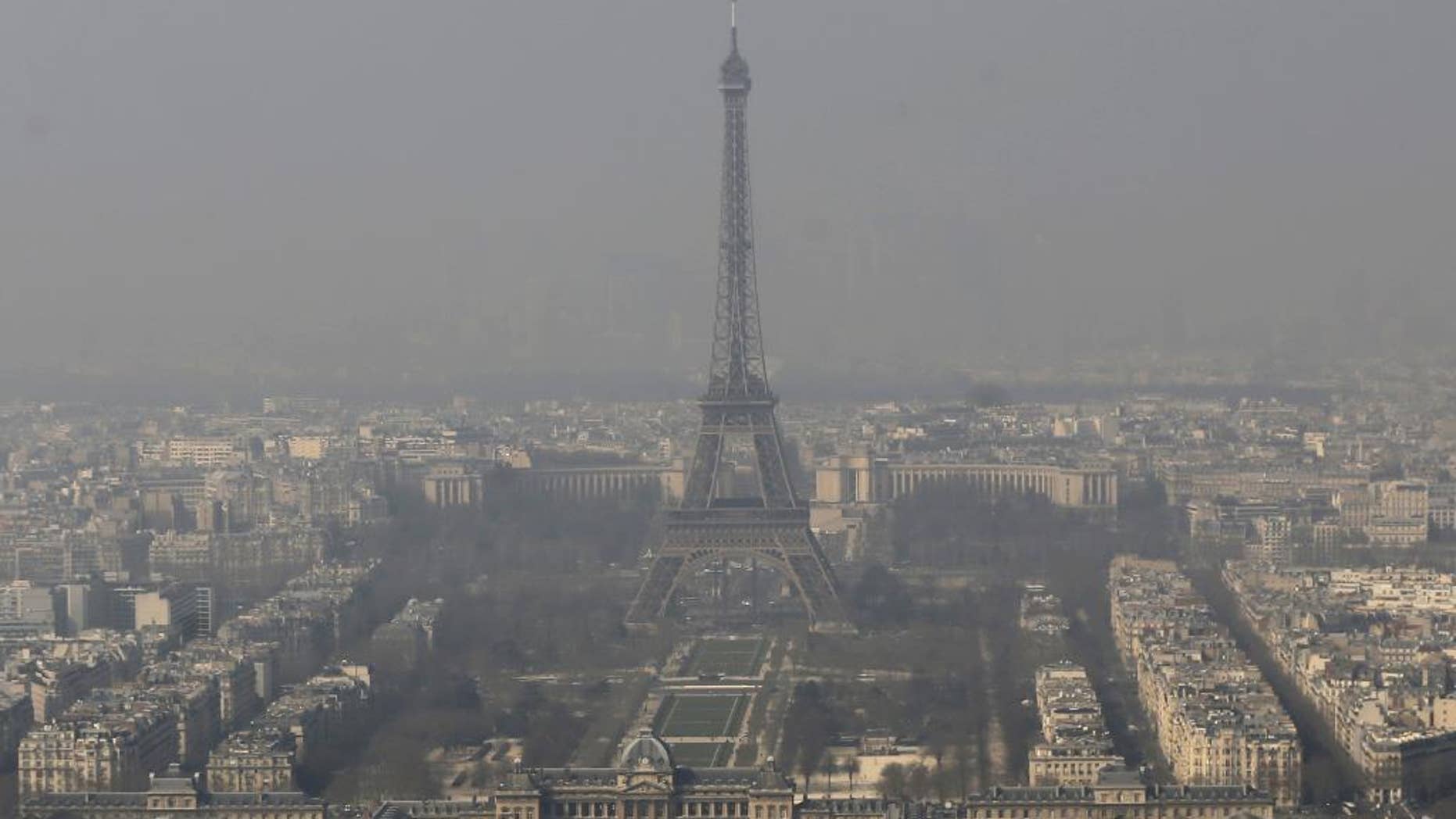 FILE - In this March 14, 2014 file photo, the Eiffel Tower, is photographed through the smog in Paris. Paris police have lowered speed limits and ordered a halt to trash burning Wednesday, March 18, 2015 as part of emergency measures triggered by a spike in air pollution — months before the city hosts a major international climate conference. (AP Photo/Jacques Brinon, File)