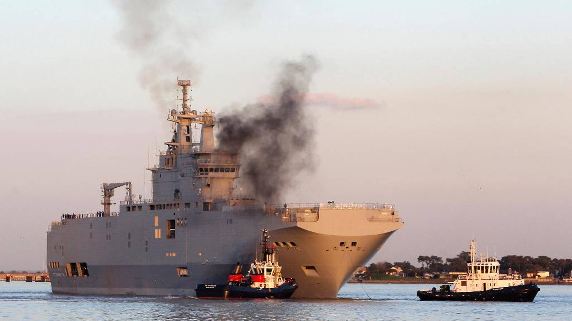 FILE - In this March 5, 2014 file photo, French-built warship BPC Vladivostock, designed to strengthen Russia's ability to deploy troops, tanks and helicopter gunships, leaves the Saint Nazaire's harbor, western France, for its test run on the open sea off coast of France. French President Francois Hollande is defending plans to deliver a 1.1 billion-euro French-made warship to Russia, despite increasing pressure for tougher European sanctions against Moscow over the fighting in Ukraine. European Union foreign ministers are meeting Tuesday July 22, 2014 in Brussels, with some calling for an arms embargo or other new punishment against Russia. (AP Photo/David Vincent, File)