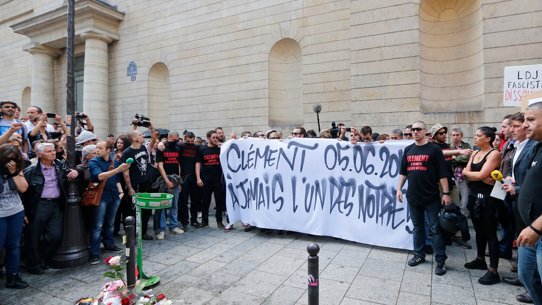 June 6, 2013: French far-left activists gather around flowers which lay at the foot of a concrete post where Clement Meric, 19, was attacked. A group of skinheads attacked a French far-left activist in the heart of Paris' shopping district, leaving the young man brain-dead in the hospital Thursday, officials said, in an attack that raised fears of increased far-right violence.